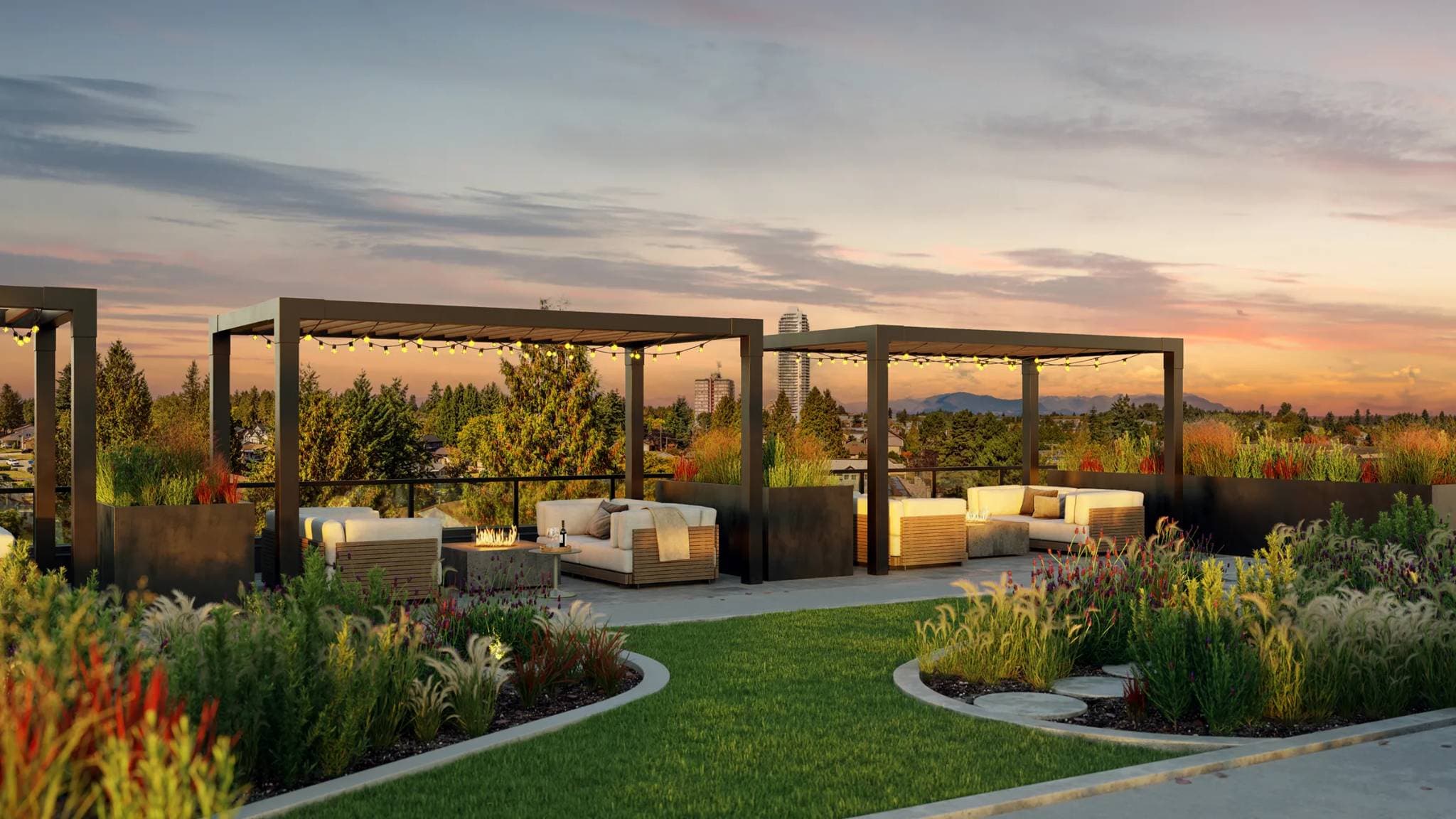 Scott + 77 – A rooftop outdoor terrace featuring black metal pergolas with string lights, cozy lounge seating, and a glowing fire table surrounded by lush planters and a manicured lawn. In the background, tree canopy, distant city towers, and mountains are visible under a warm dusk sky.
