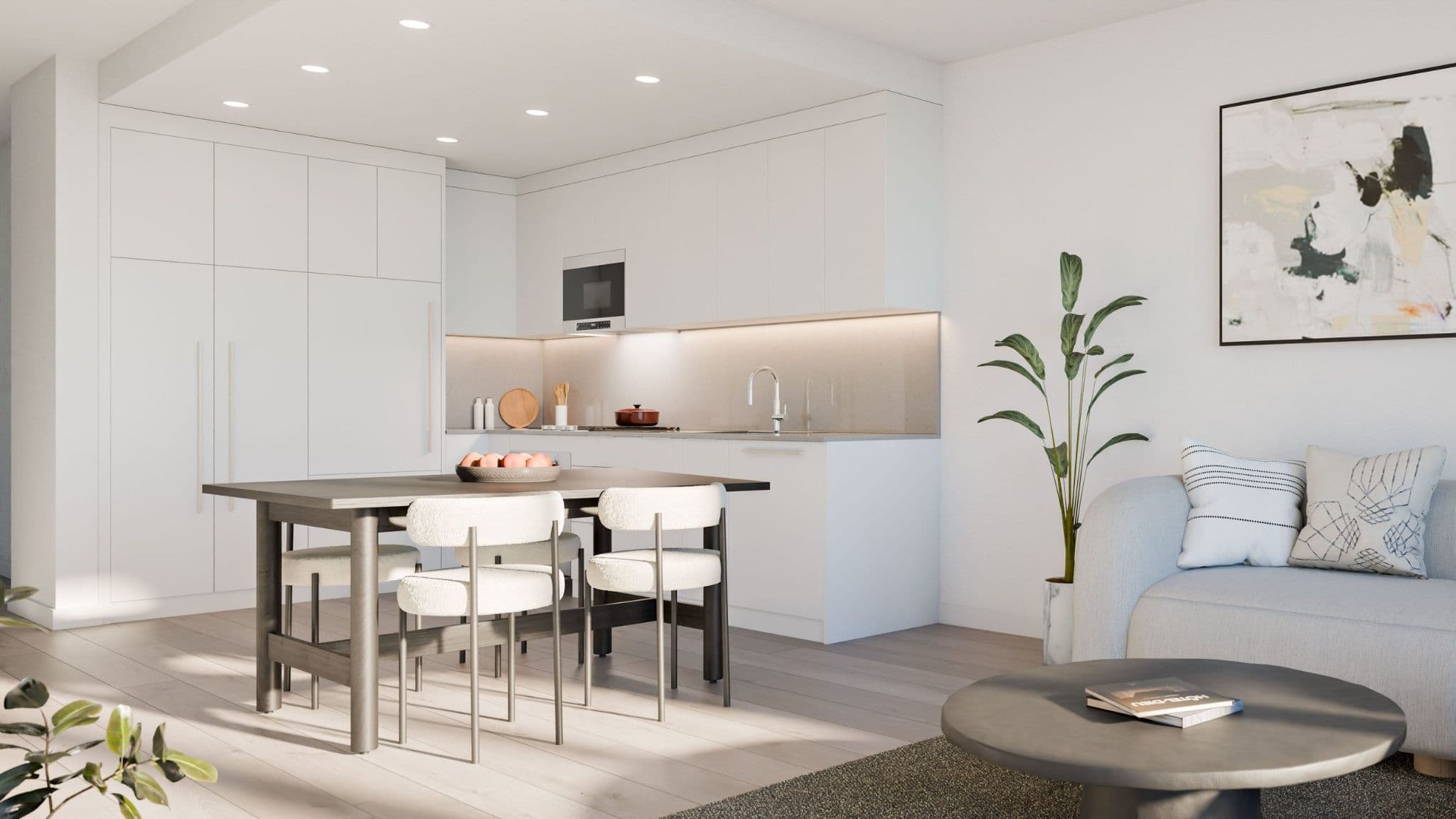 Exeter Hall – A bright, open-concept kitchen and living area featuring seamless flat-panel white cabinetry, recessed lighting, and under-cabinet illumination. In the foreground, a dark wood dining table is paired with contemporary upholstered chairs, transitioning into an adjacent lounge space with light hardwood floors and potted greenery.