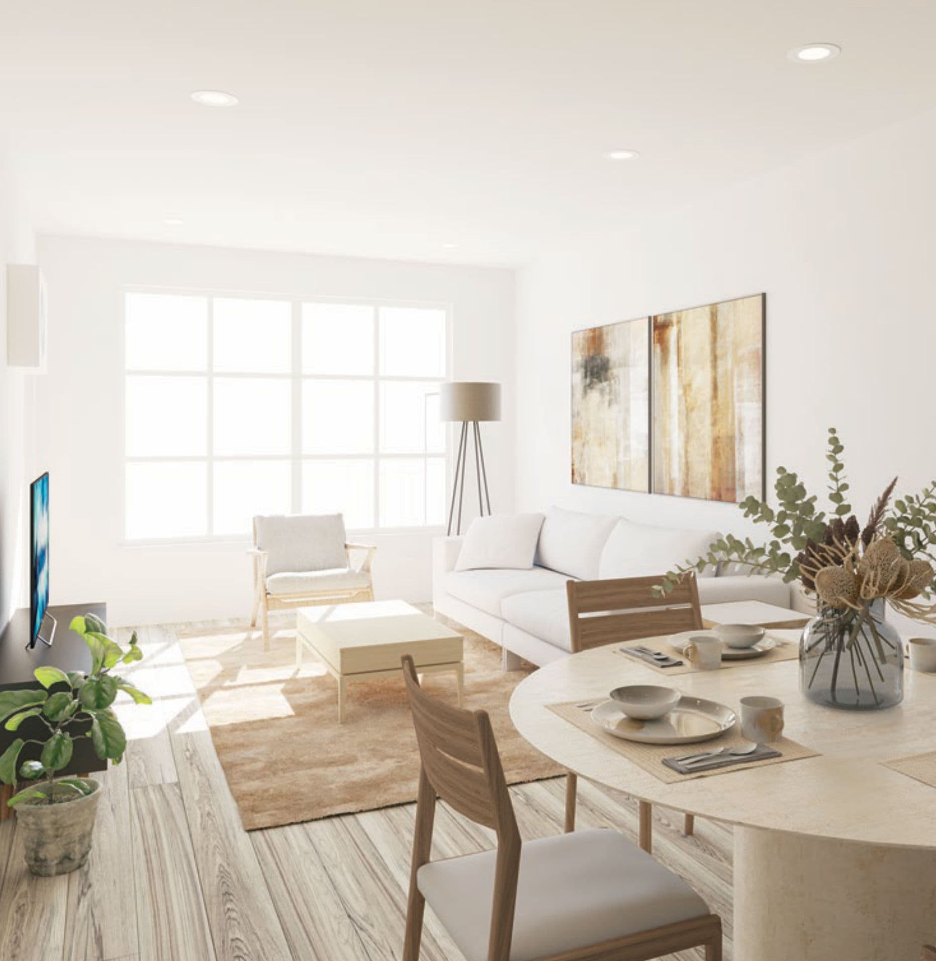 The North – Bright open-concept living and dining room with a white sofa, wood dining table and chairs, area rug, and large windows.