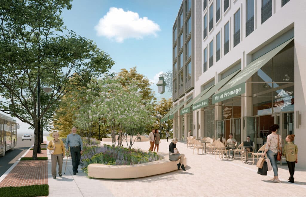 Mackin Parkside – A sunny plaza-level retail street with cafe tables, green awnings reading 'Vin et Fromage', and pedestrians walking past landscaped seating.