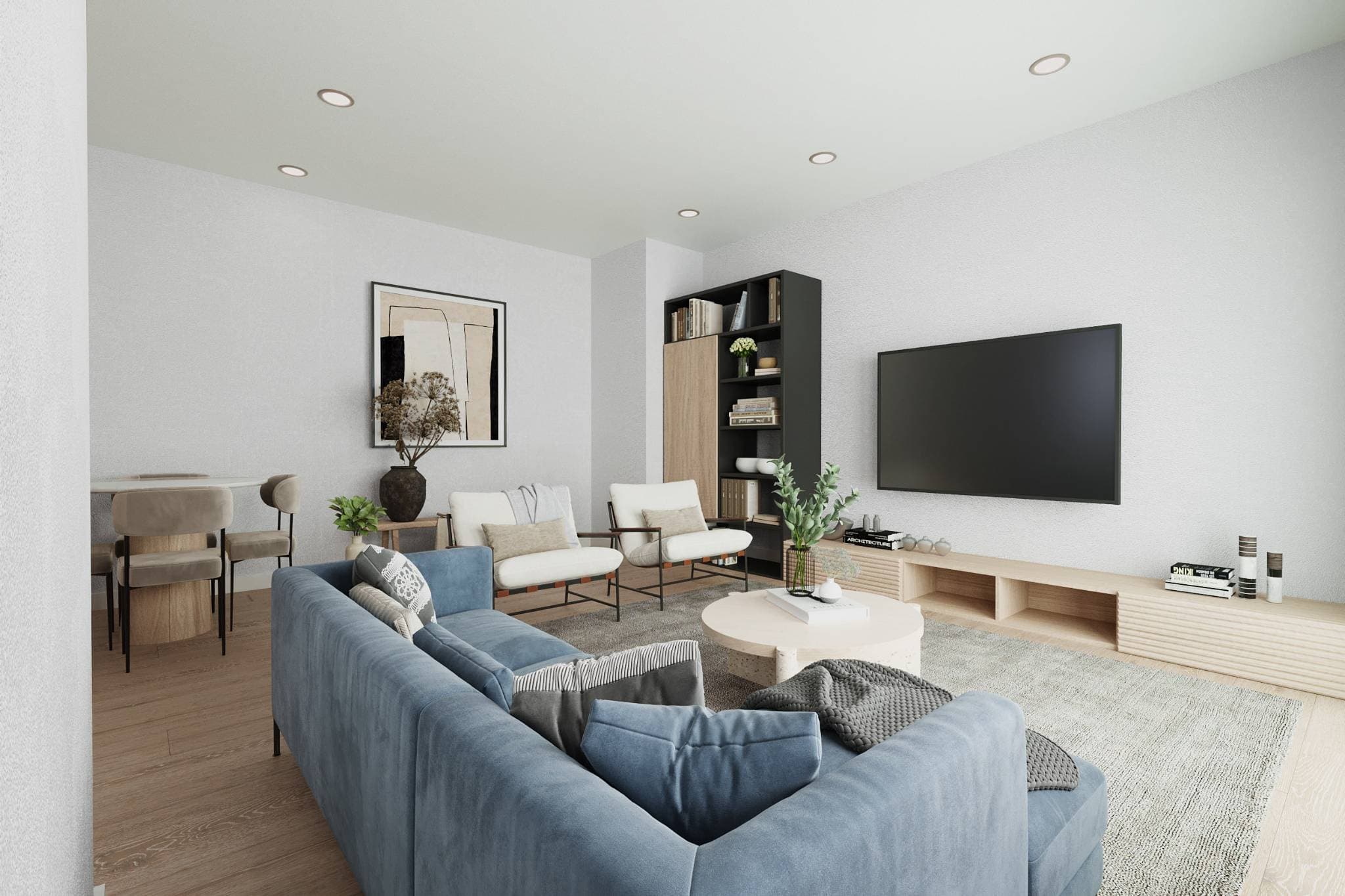 La Riviere – A living room with a blue sectional sofa, wall-mounted TV, dark bookshelf unit, and a dining area visible to the side.