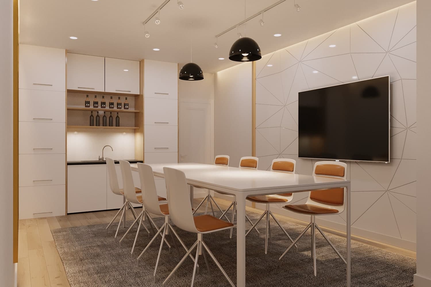 La Riviere – A shared meeting/lounge room with a long white table, orange-cushioned chairs, wall-mounted TV, and a small wet bar with shelved bottles.
