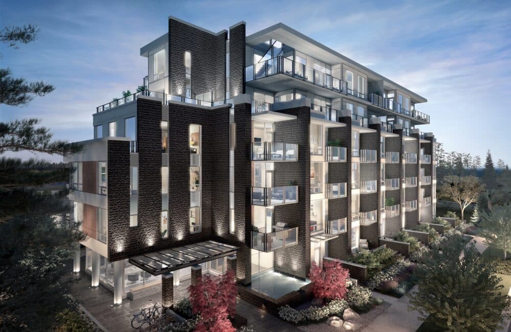 Slate & Ash – Twilight exterior view of the building's corner with dark stone cladding, illuminated balconies, and a small water feature at the entrance.