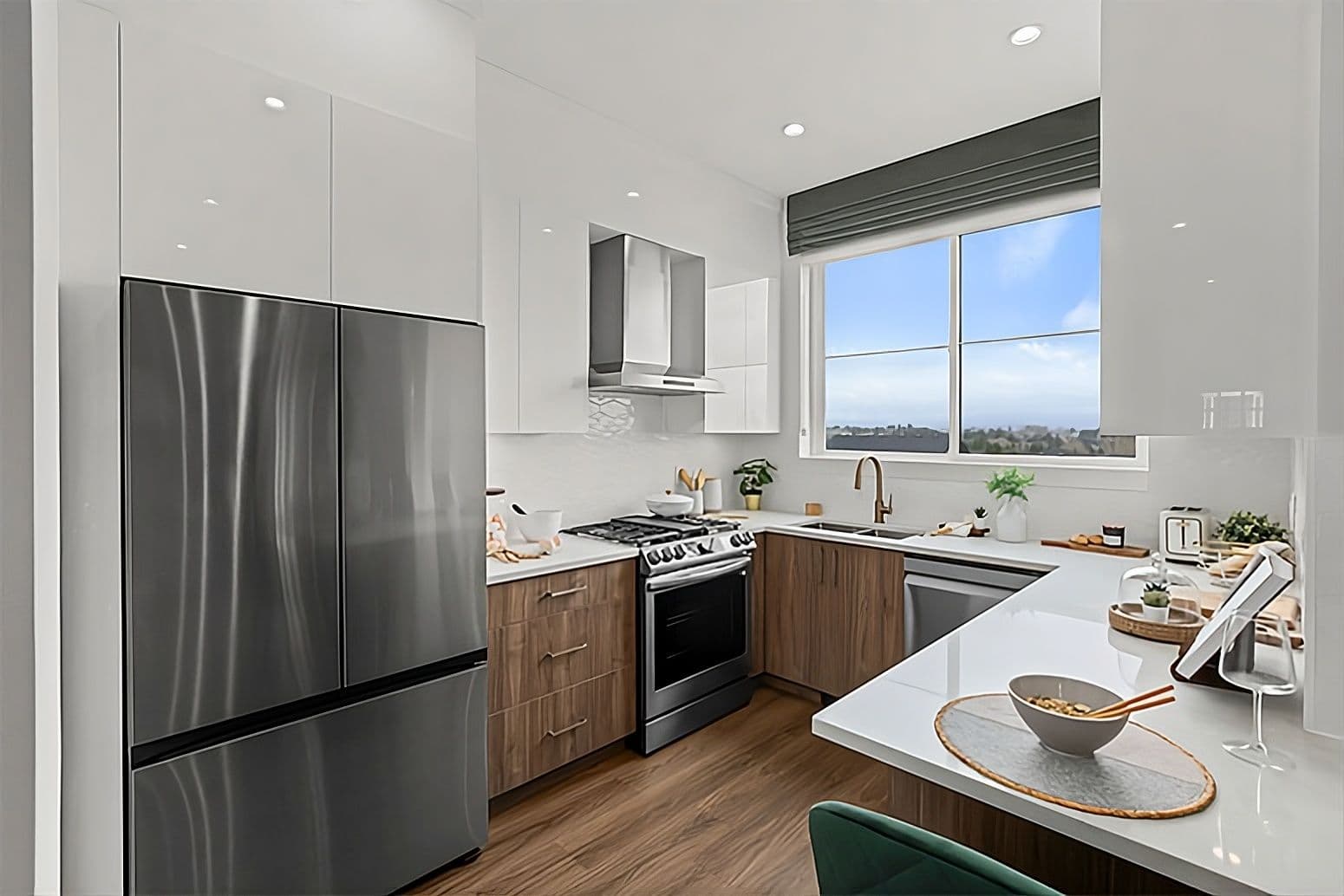 Harmony – Kitchen with white cabinets, wood-tone lower cabinets, stainless fridge, gas range, and a window showing a hillside view.