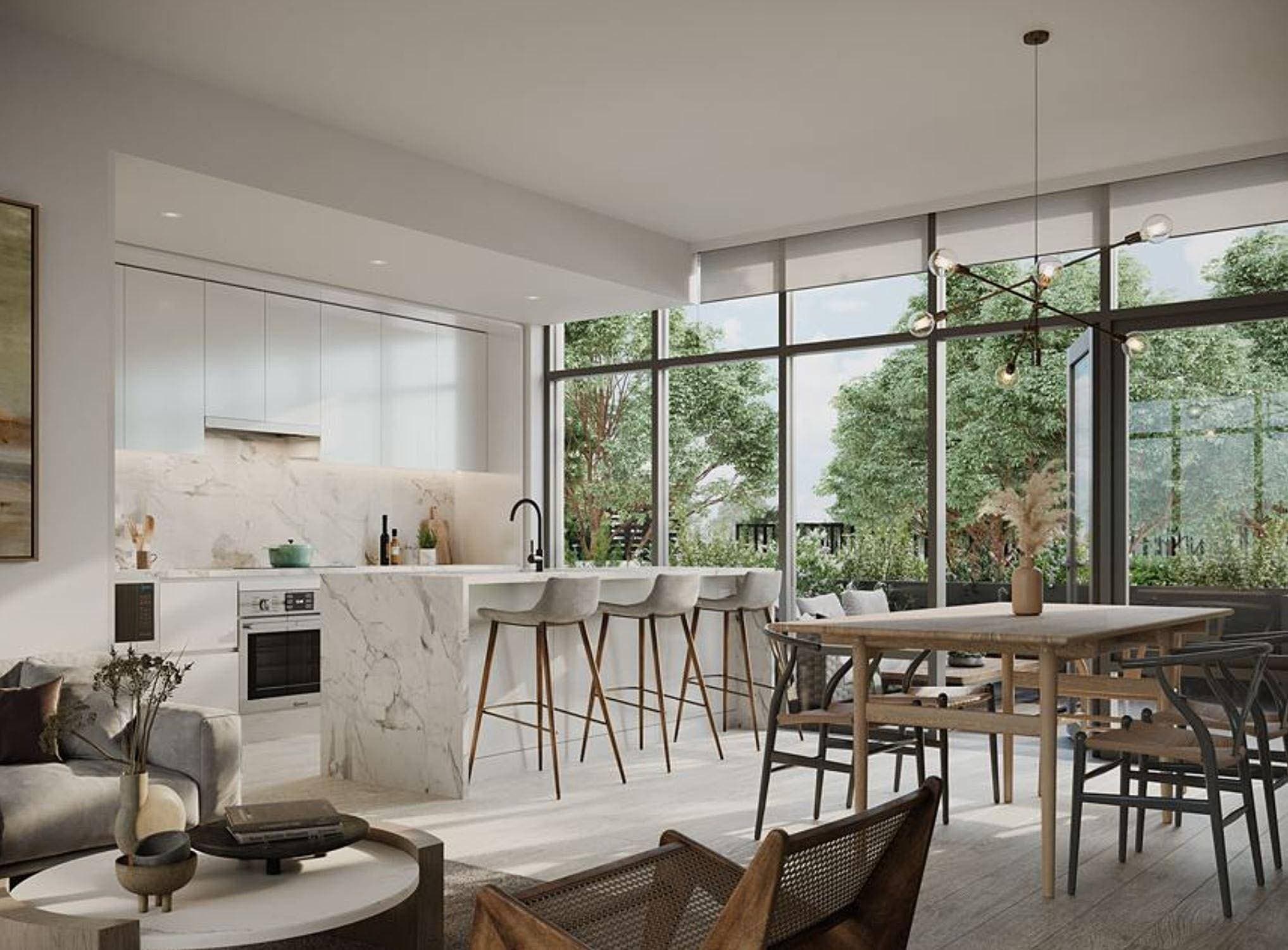 Central Park House – A modern open-concept kitchen and dining area featuring a waterfall marble island with four barstools, sleek white cabinetry, and a wooden dining table under a stylish sputnik chandelier. Large floor-to-ceiling windows flood the bright space with natural light and offer views of lush green trees outside.