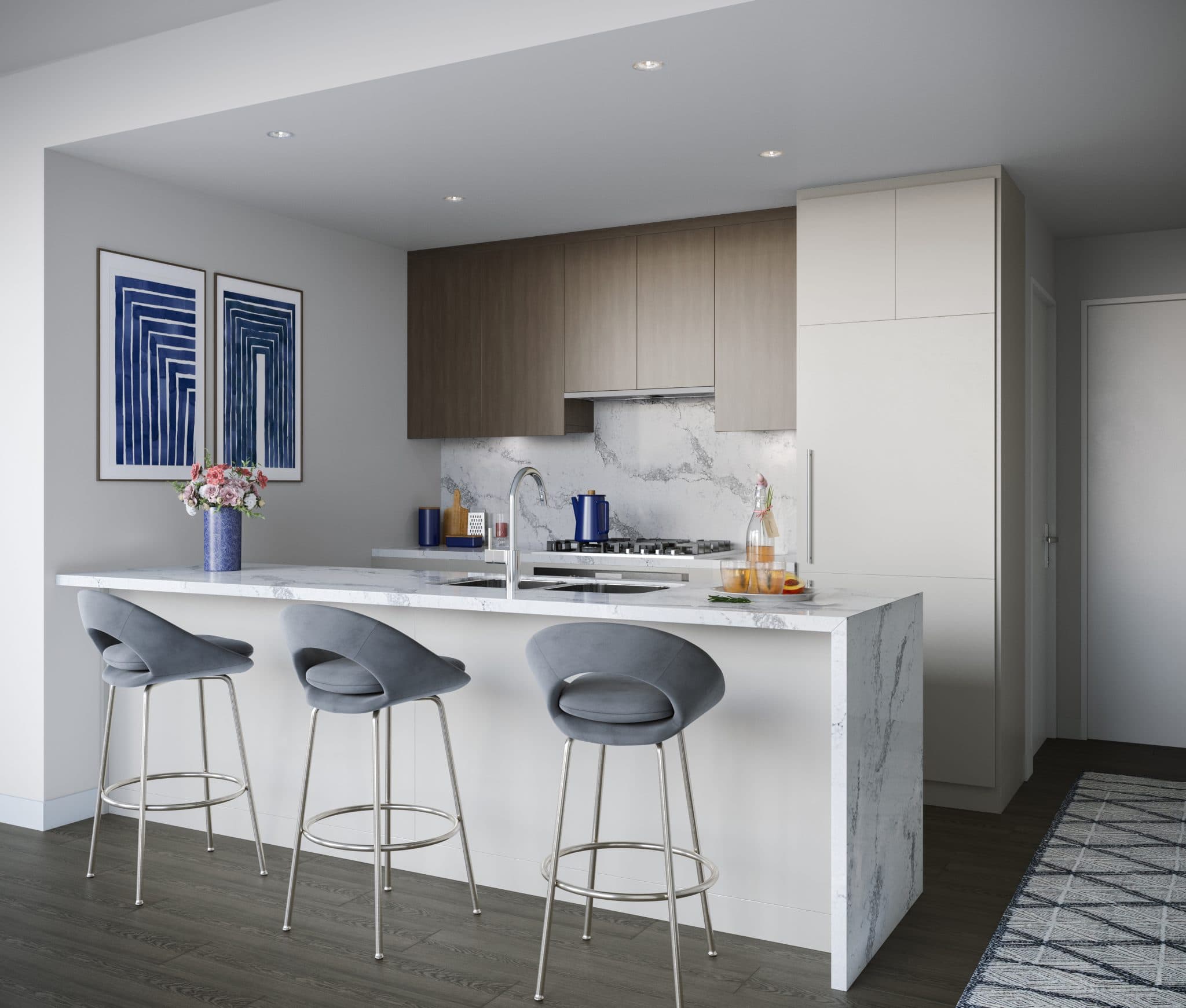 Vue – A modern open-concept kitchen features a marble waterfall island with an undermount sink and three grey velvet barstools. In the background, sleek two-tone cabinetry in warm wood and matte white complements a matching marble backsplash and stainless steel gas cooktop.