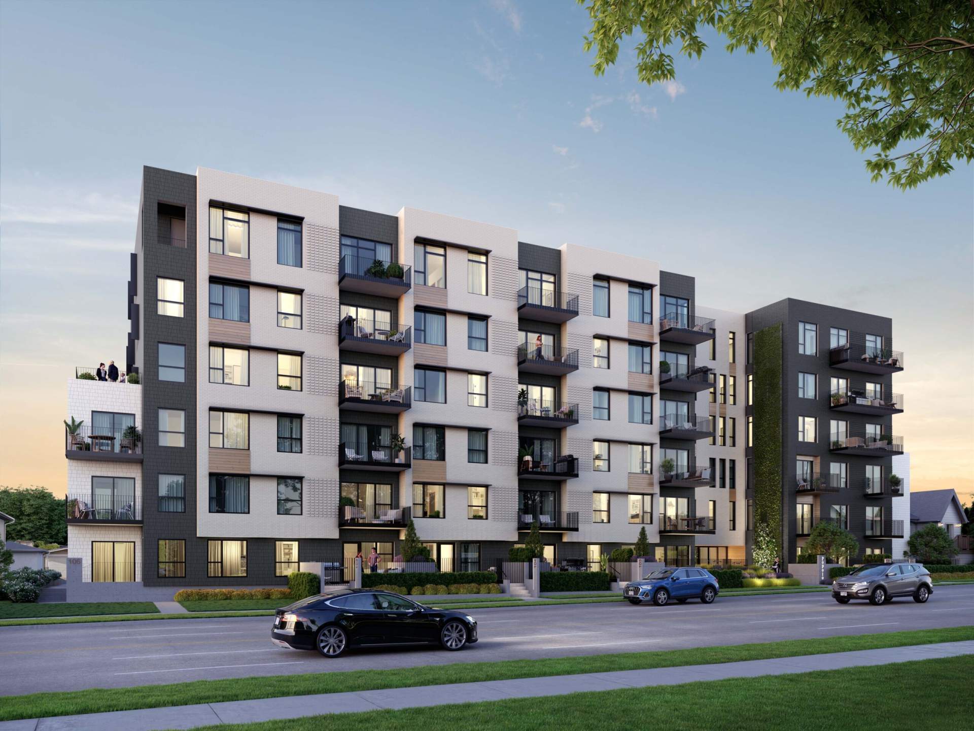Popolo – Street-level view at dusk of a six-story condo building with dark and cream paneled sections, balconies, and cars parked along the street in front.