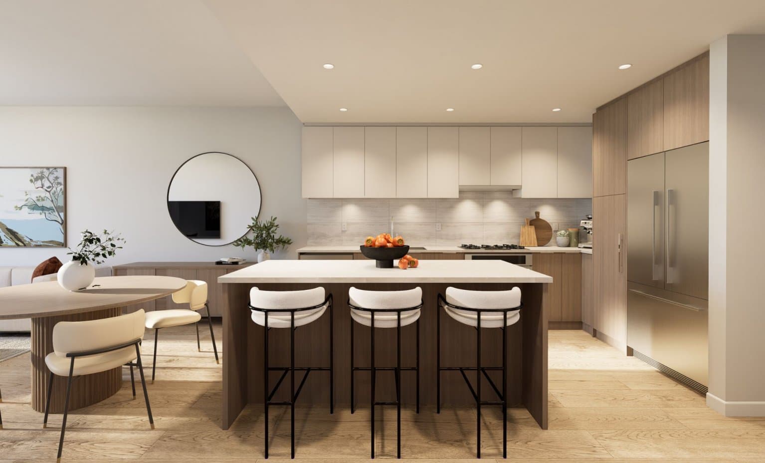 Goldfinch – Modern kitchen with a large island, white barstools, light cabinetry, and a built-in wall oven and stainless refrigerator.