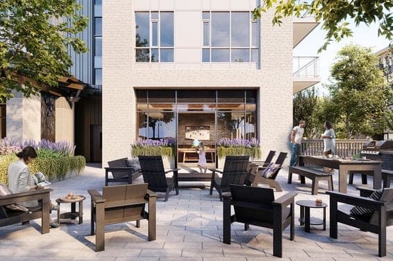 Parkside at Lynn – Outdoor courtyard patio with adirondack-style lounge chairs and small side tables, residents seated and standing near a covered lounge area at the base of the building.