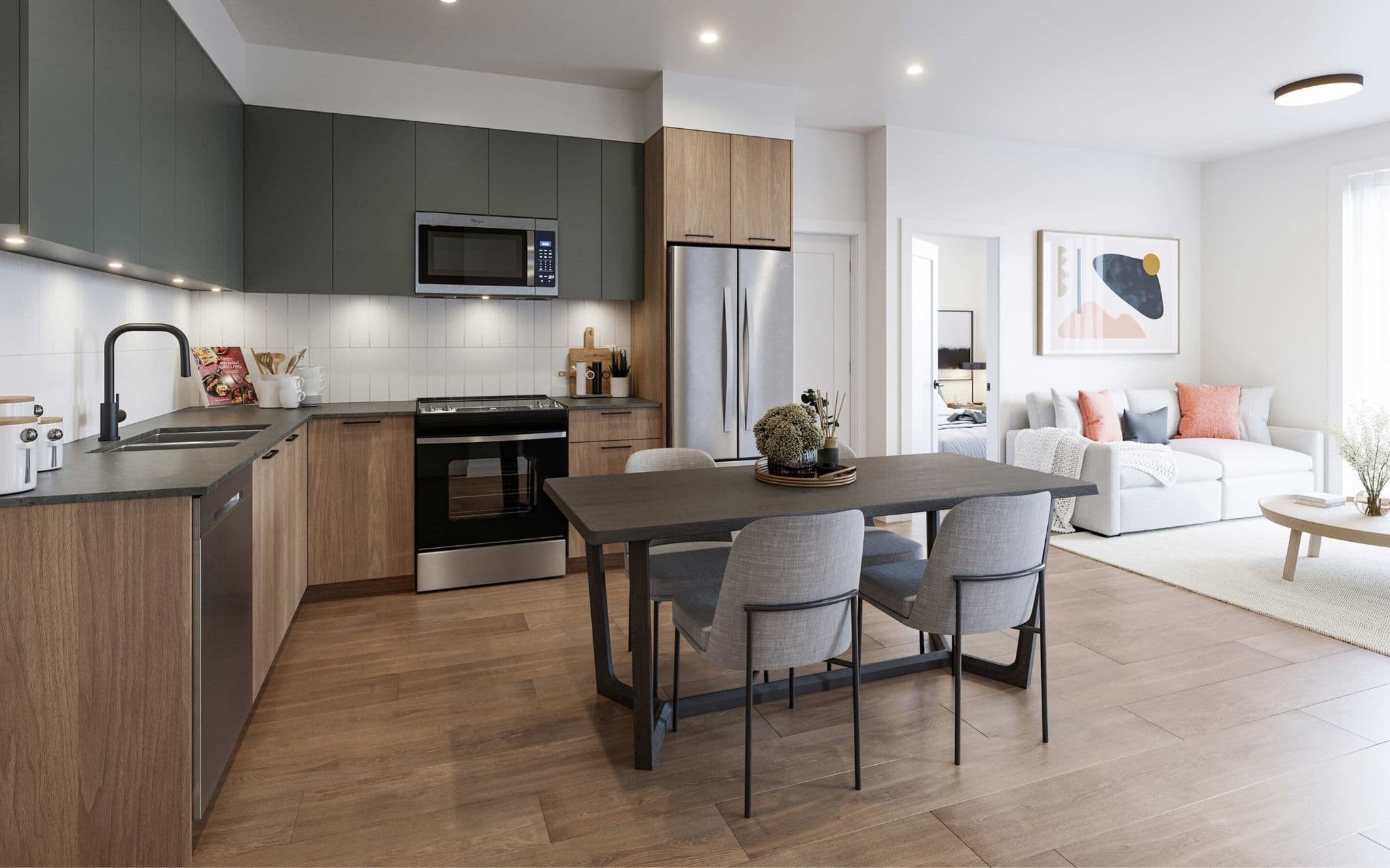 City and Laurel – An open-concept modern kitchen and dining area featuring two-tone cabinetry in charcoal grey and light wood, stainless steel appliances, and a dark wood dining table with grey upholstered chairs. Light wood floors extend past the dining space toward an adjacent bright living room and a visible doorway into a bedroom.