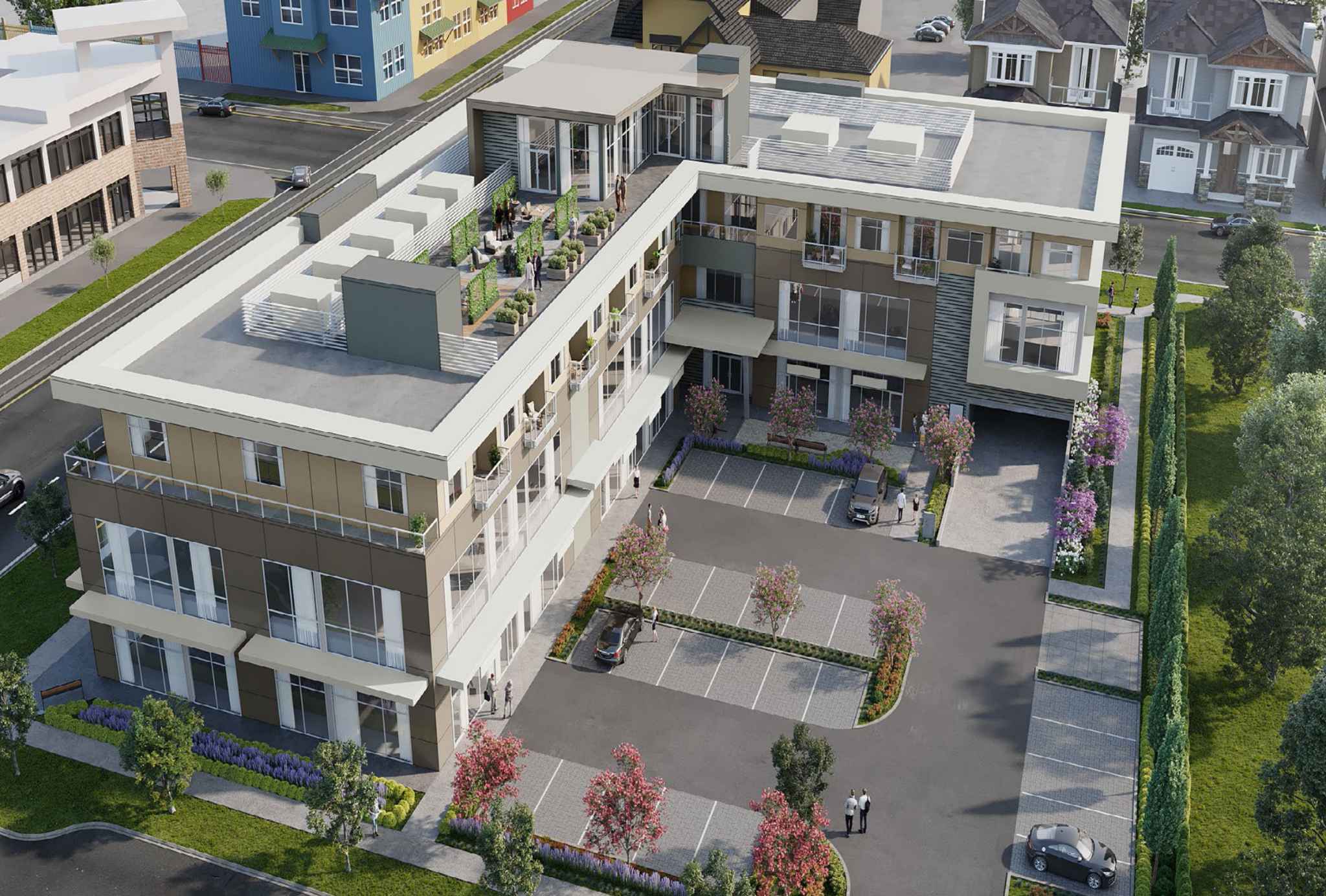 72 Crossroads – Aerial view of a low-rise condo building with a rooftop terrace, surrounded by a parking lot, neighboring houses, and landscaped gardens.