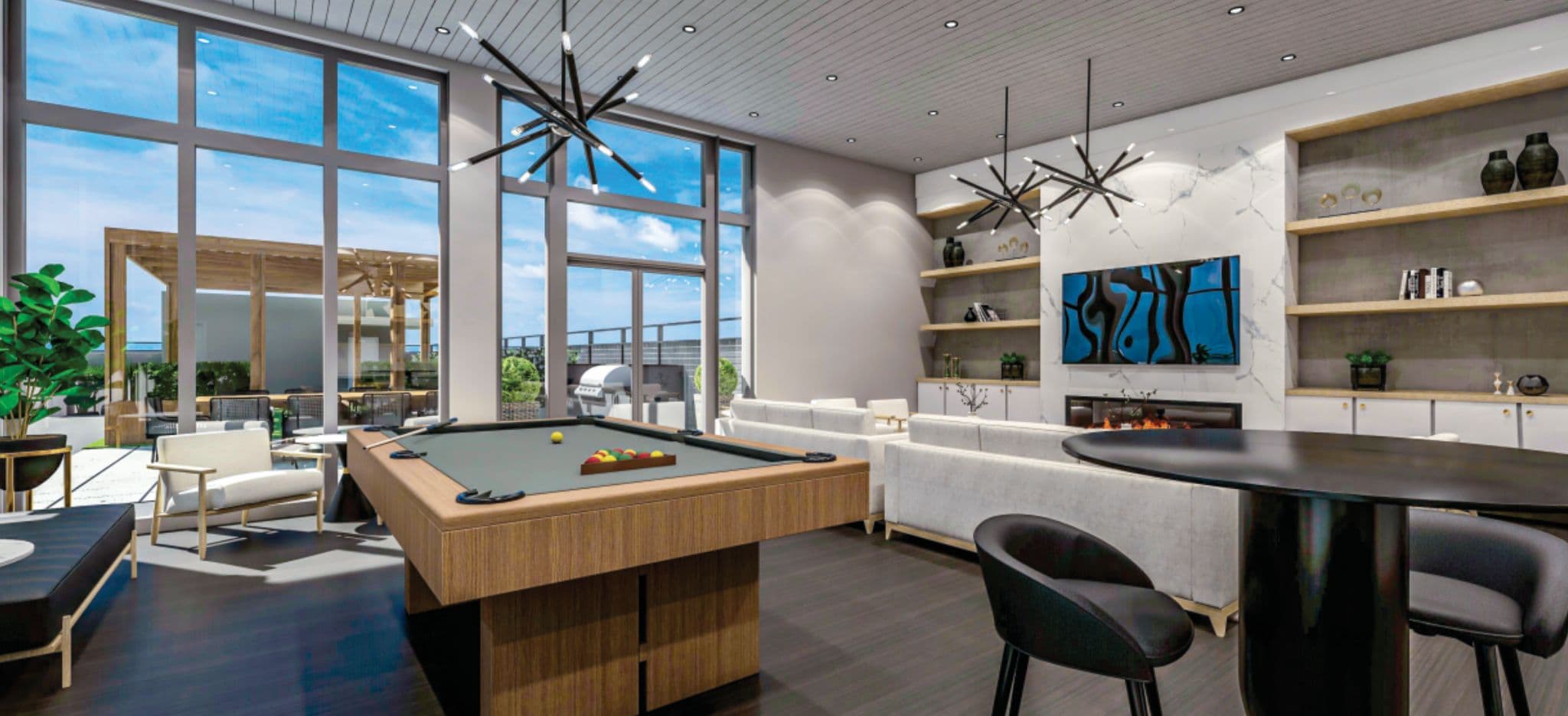 72 Crossroads – Indoor rooftop lounge with a pool table, fireplace, built-in shelving, and seating area opening onto an outdoor terrace with a barbecue.