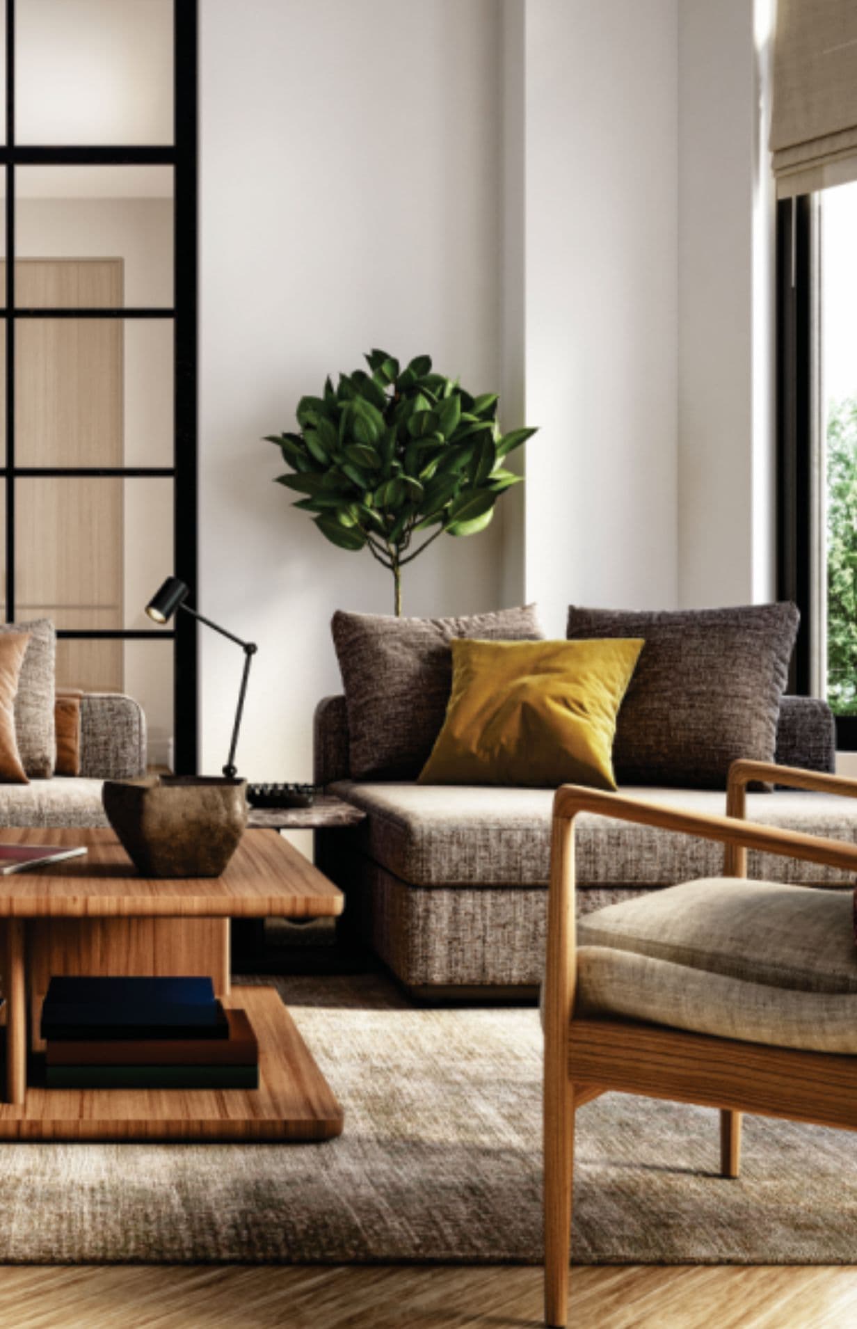 72 Crossroads – Close-up of a staged living room corner with a grey sectional sofa, mustard accent pillow, wood coffee table, and an armchair.