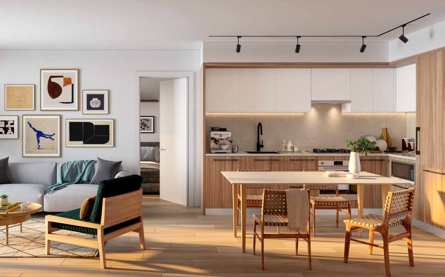 Frame – Open-concept living room and kitchen with a gallery wall of framed art, grey sectional sofa, wood dining table, and woven dining chairs.