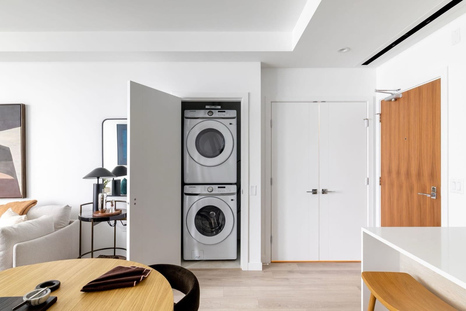Pier West – Stacked front-load washer and dryer inside a closet near the unit's entry doors.