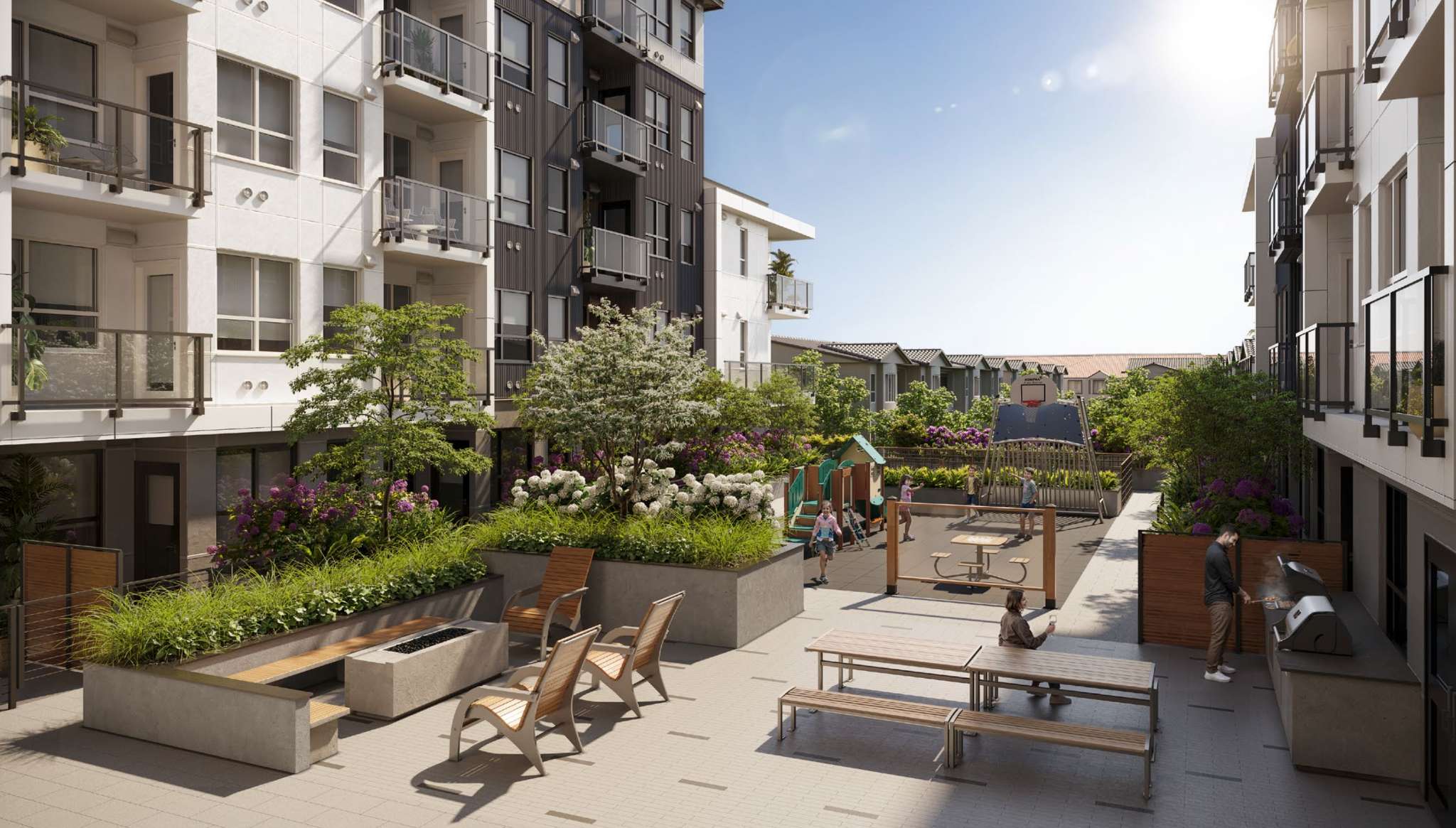 The Merchant – Outdoor courtyard amenity space with picnic tables, lounge chairs around a fire feature, a BBQ grill area, and a children's play structure with a basketball hoop.