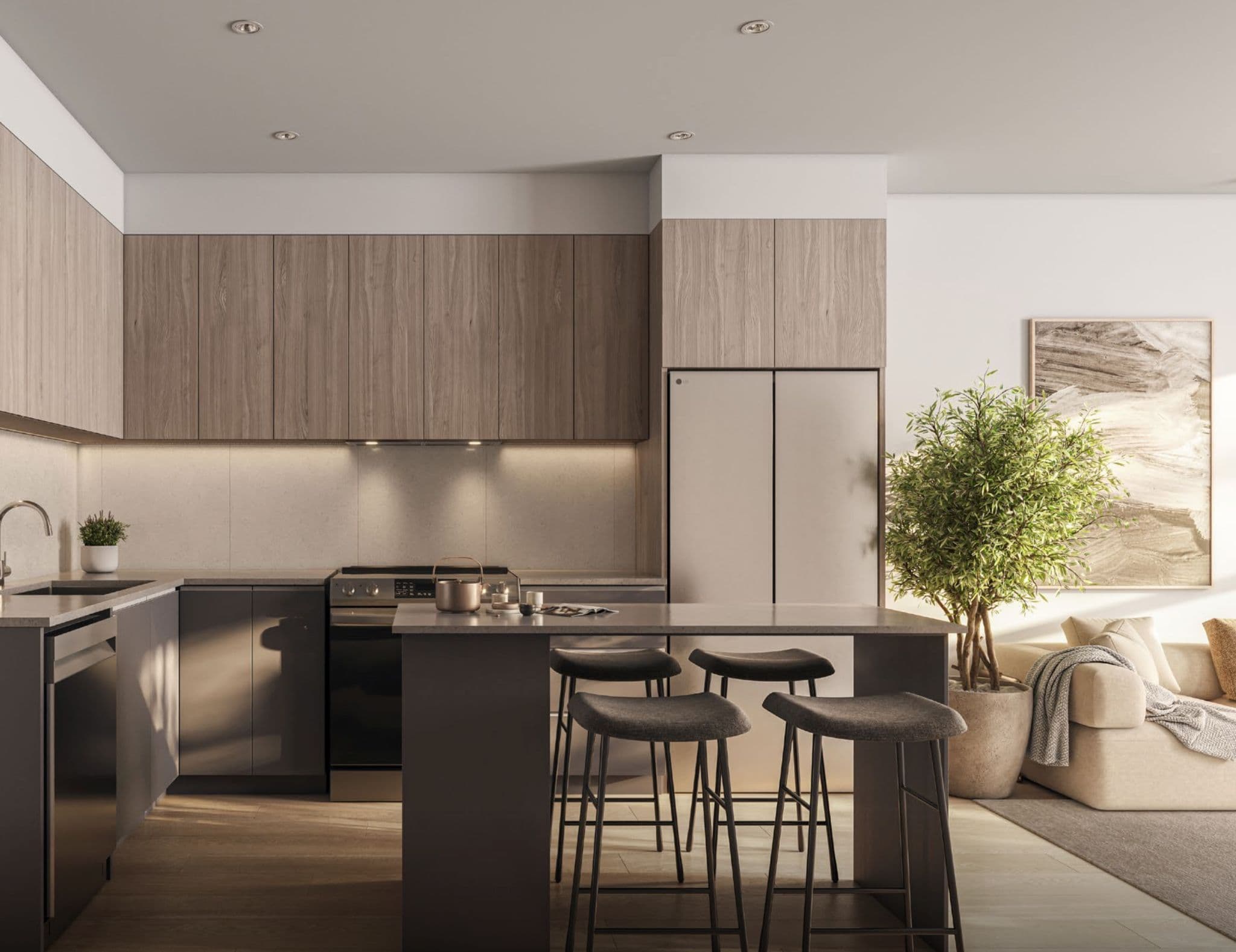 The Merchant – Kitchen with wood-toned upper and lower cabinetry, a stainless refrigerator, an island with bar stools, and an open living area with a sofa in the background.