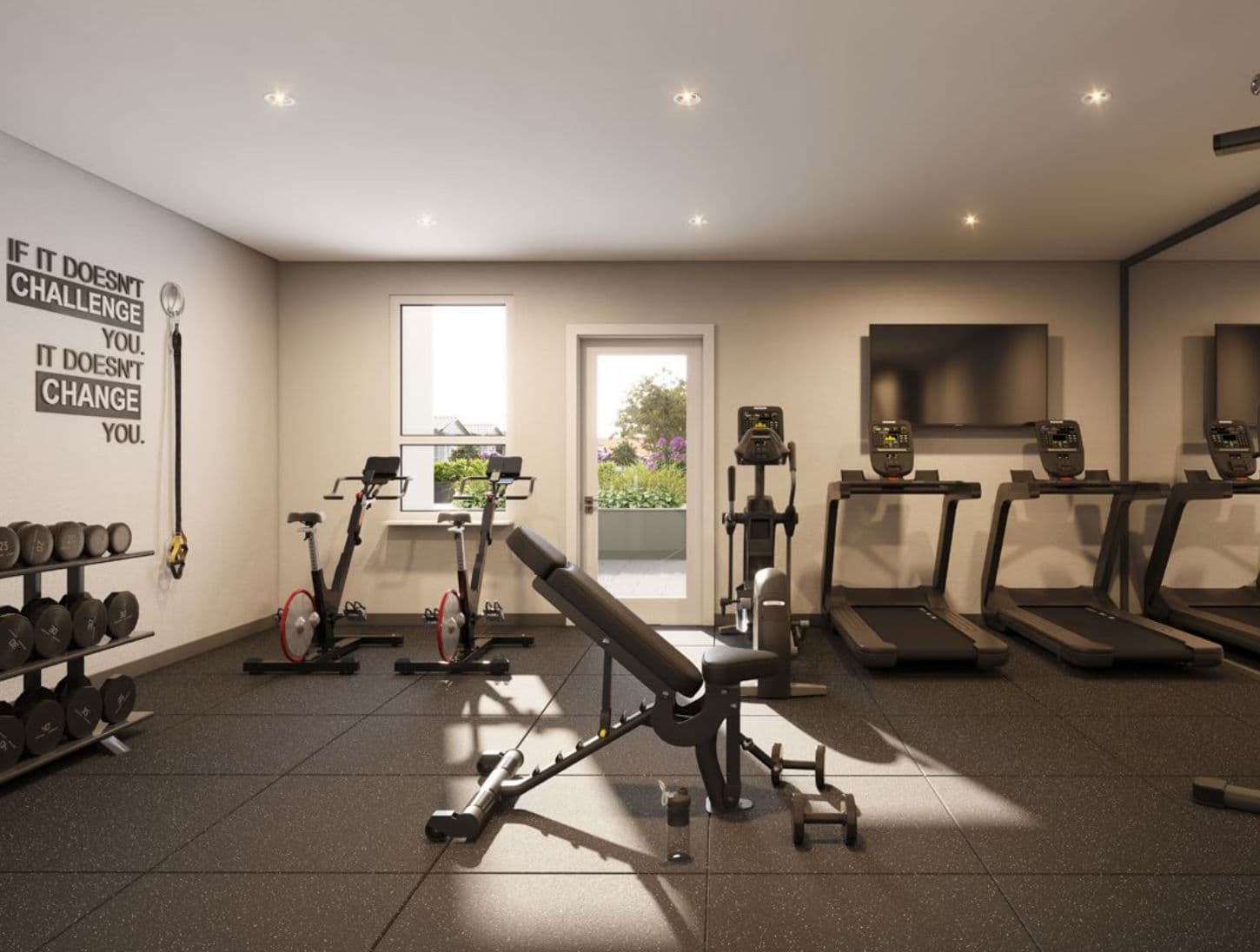 The Merchant – Fitness room with rows of treadmills, an elliptical machine, spin bikes, a weight bench, a dumbbell rack, and a motivational wall quote.