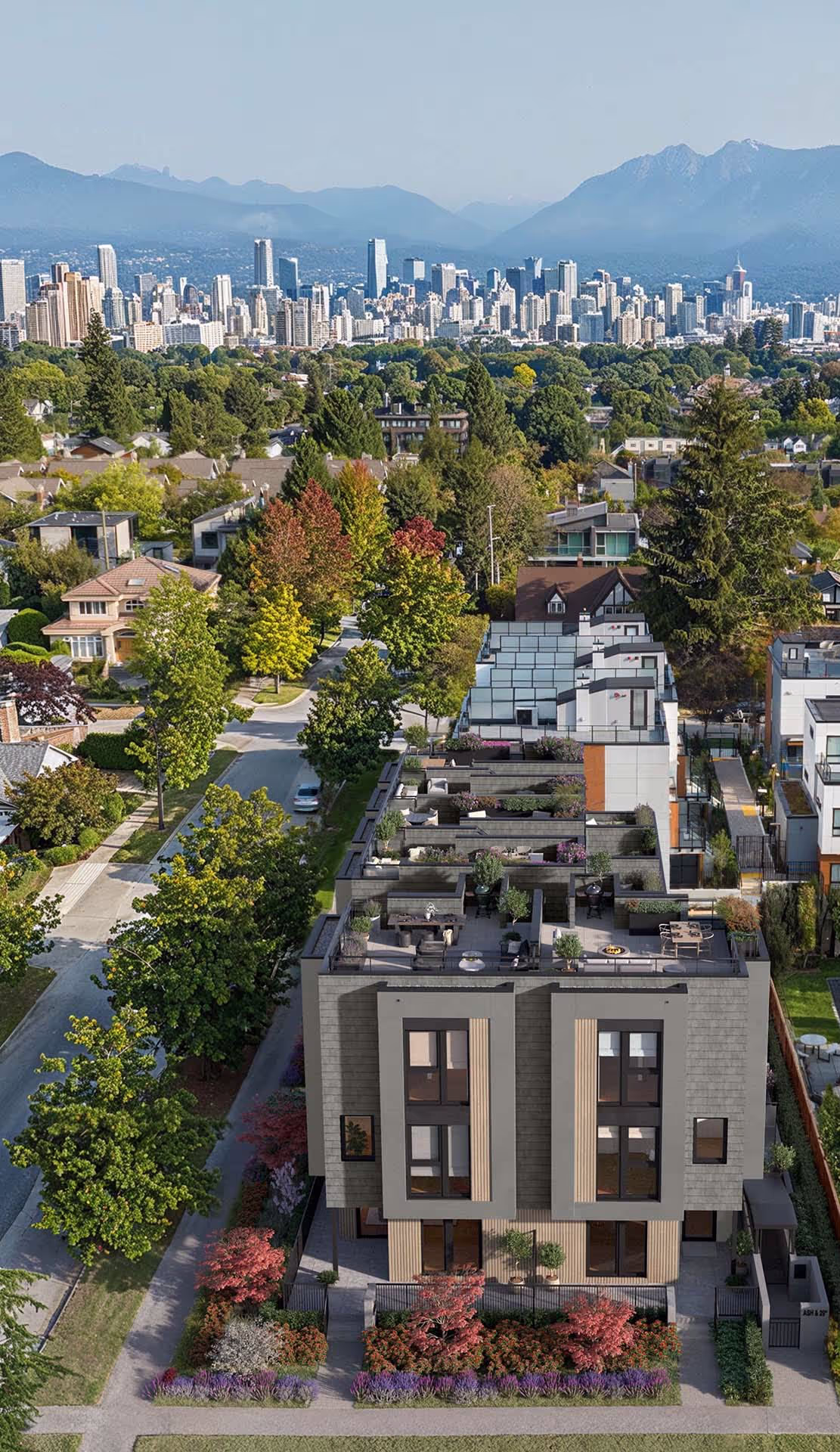 Nolia – An elevated perspective showcases modern multi-level townhomes with private landscaped rooftop terraces along a tree-lined residential street. In the background, lush green canopies stretch toward a distant city skyline beneath a clear mountain range under bright daylight.