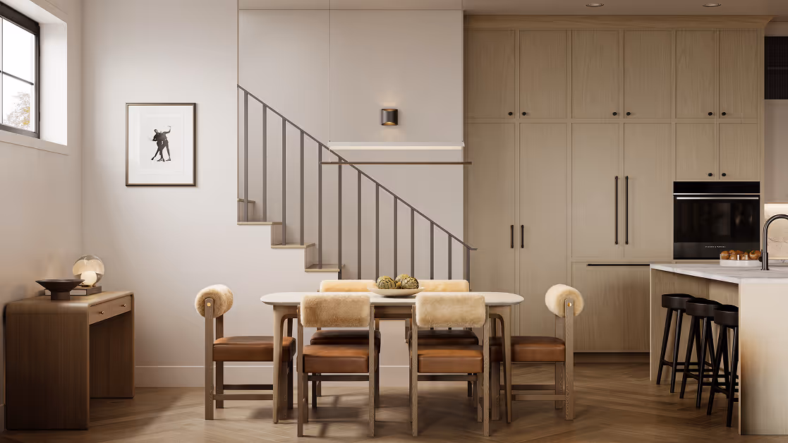 Wallace – A sophisticated dining and kitchen area featuring a marble-topped dining table with leather-and-shearling upholstered chairs, set over herringbone wood floors. In the background, floor-to-ceiling light wood cabinetry seamlessly integrates high-end appliances, adjacent to an open staircase with minimalist metal railings.
