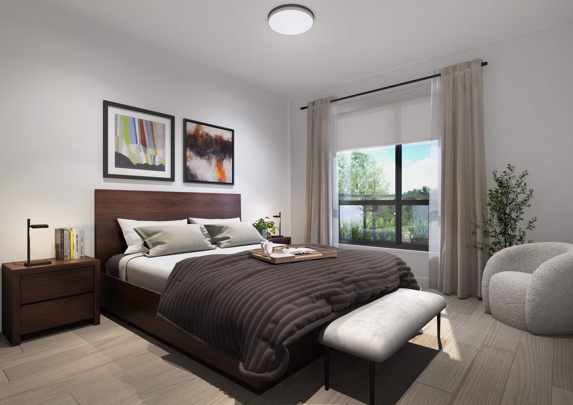 Guilden – A bedroom with a dark wood bed frame, a charcoal ribbed coverlet with a breakfast tray, two framed art prints above the headboard, a bouclé accent chair, and a window looking out to greenery.