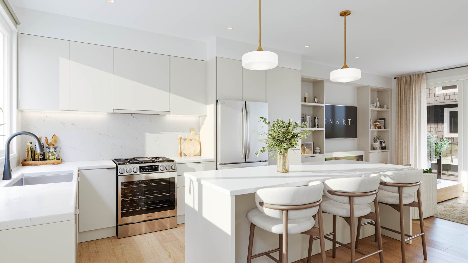 Kin & Kith – A white contemporary kitchen with flat-panel cabinets, island with counter stools, brass pendant lights, and stainless steel appliances.