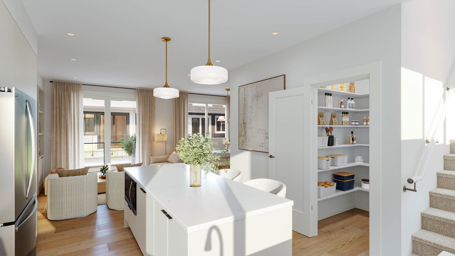 Kin & Kith – Kitchen island overview highlighting built-in microwave, open walk-in pantry, staircase with white handrail, and living area beyond.