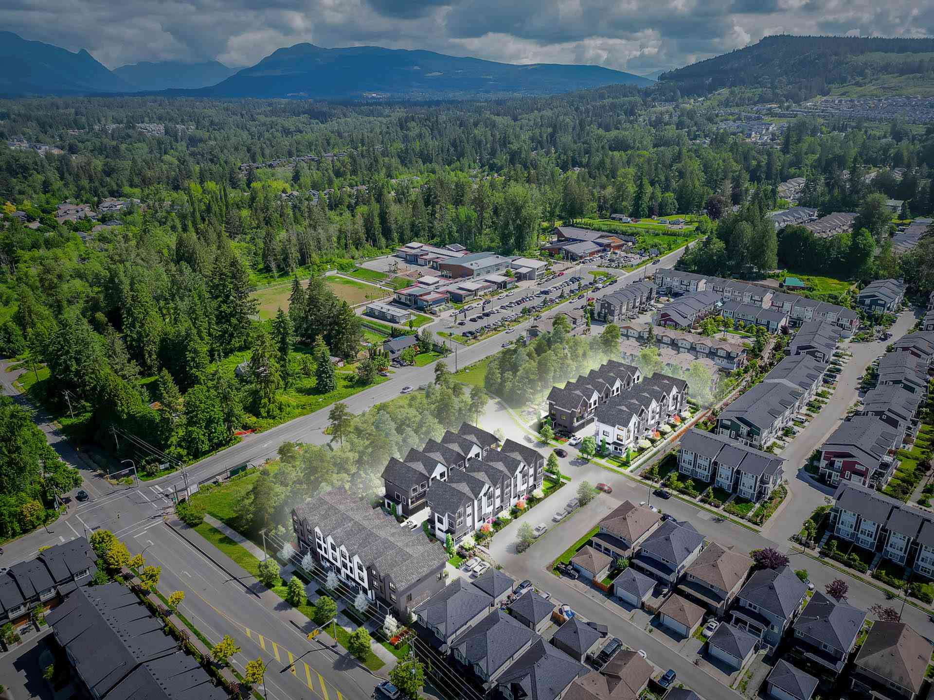 Kin & Kith – Aerial drone view highlighting the townhome community location within the surrounding residential neighborhood, forests, and distant mountains.