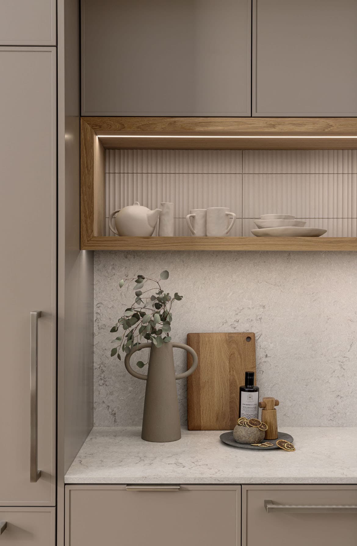 Naímo – Kitchen detail showing an open wood shelf with ceramic teapot, mugs and bowls above a countertop with a vase, cutting board and oil bottle.