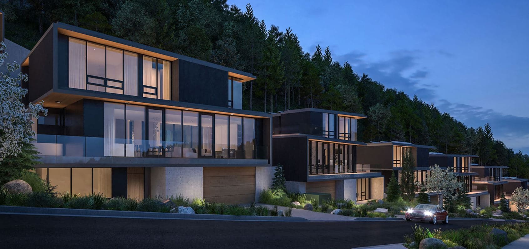 The Collection – Dusk rendering of modern dark-clad multi-level homes with large glass walls and wood accents, built into a treed hillside, with a car in the driveway.