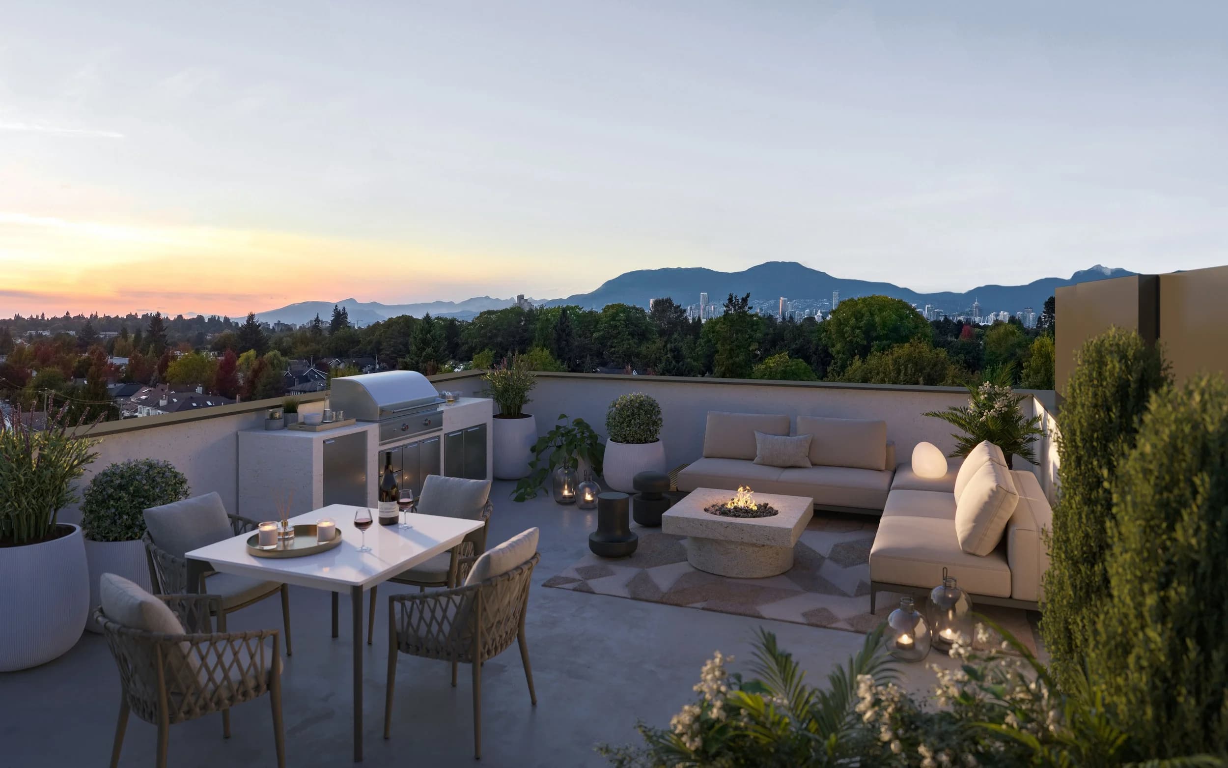King and Columbia – A dusk view of a luxurious outdoor rooftop terrace equipped with a built-in BBQ kitchen, a dining table set for wine, an L-shaped sofa, and a burning fire pit table. Lush green treetops, distant city skylines, and mountain silhouettes are visible against a warm sunset sky.