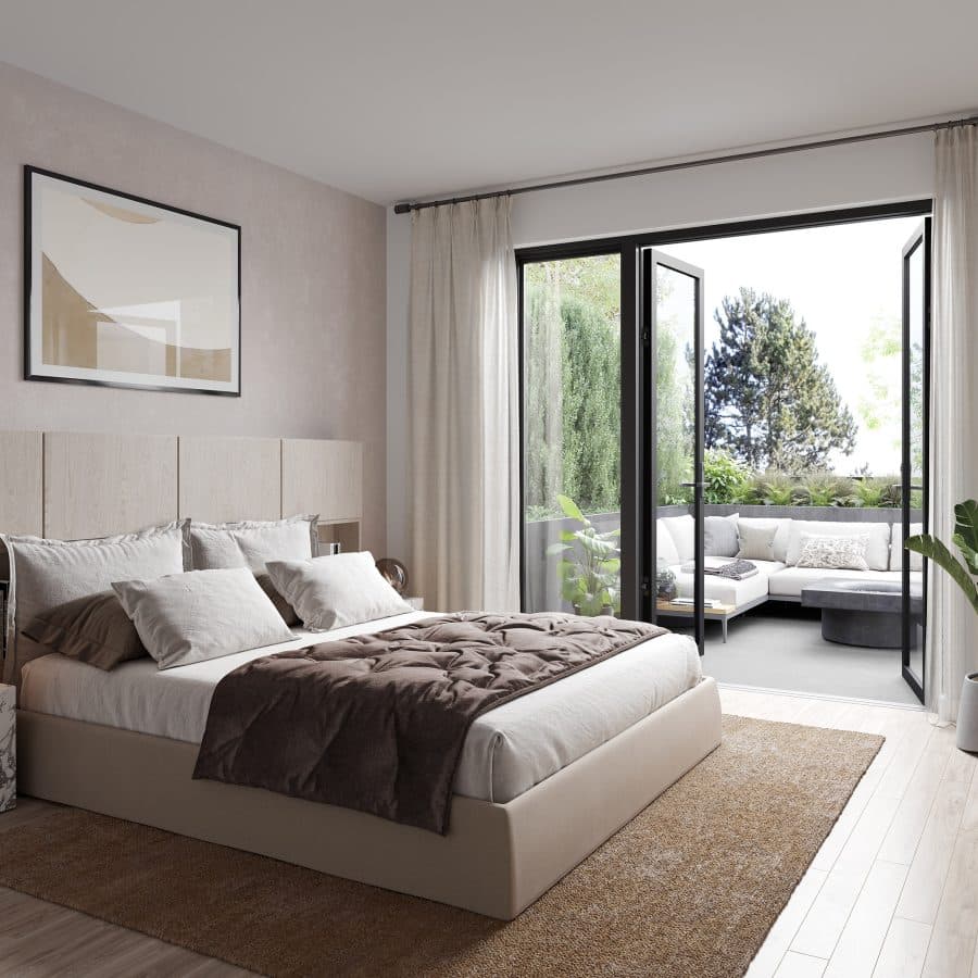 King and Columbia – A modern, sunlit bedroom featuring a neatly dressed bed with a dark throw blanket, light wood paneling, and a large framed artwork on a soft textured wall. Black-framed glass doors open wide onto a private outdoor patio furnished with an L-shaped sectional sofa surrounded by lush greenery.