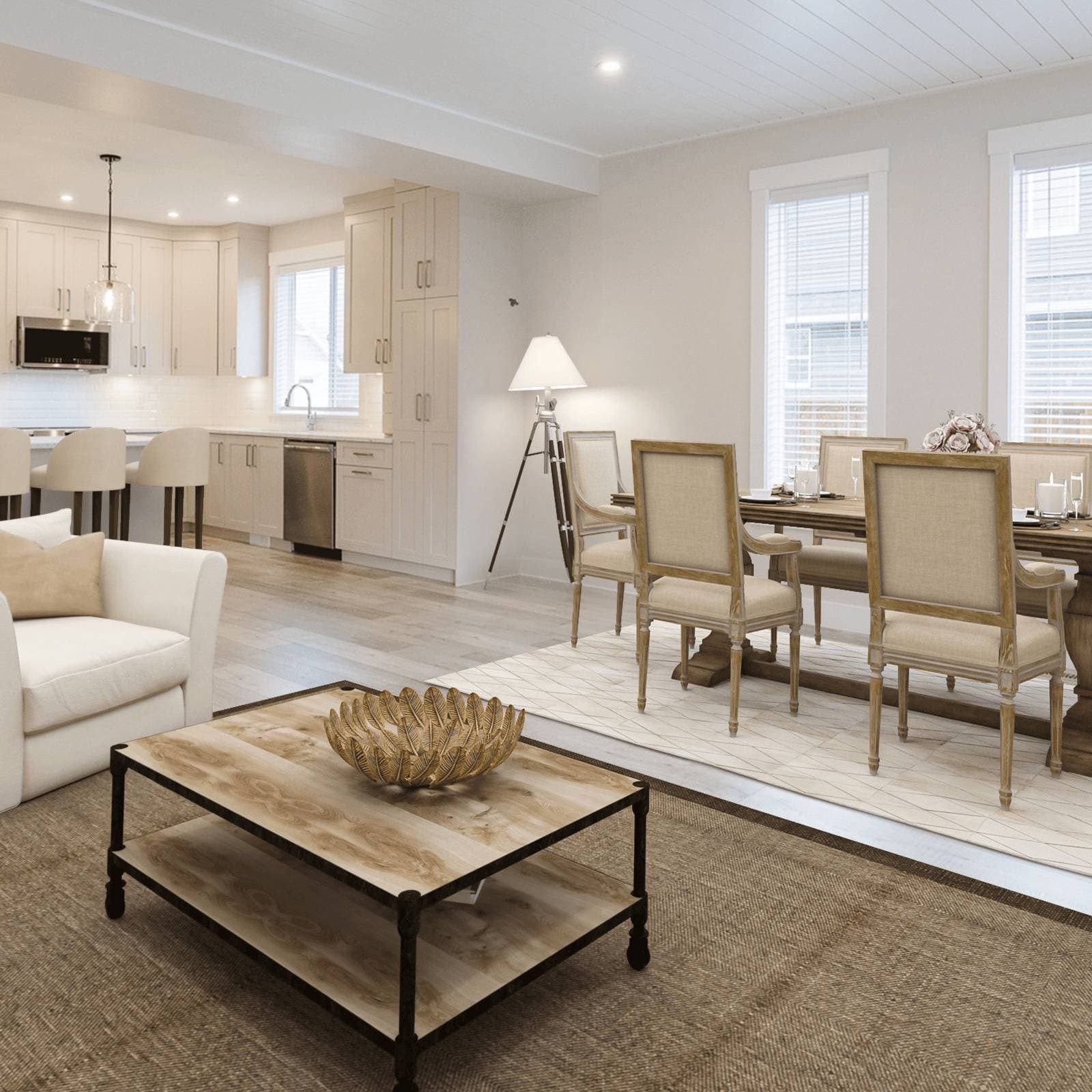 Malloway Village – A bright, open-concept living and dining area seamlessly connected to a modern kitchen with cream-colored shaker cabinetry. The space is styled in neutral tones with a rustic wooden coffee table, an elegant dining set on a geometric rug, and light wood flooring illuminated by natural window light.