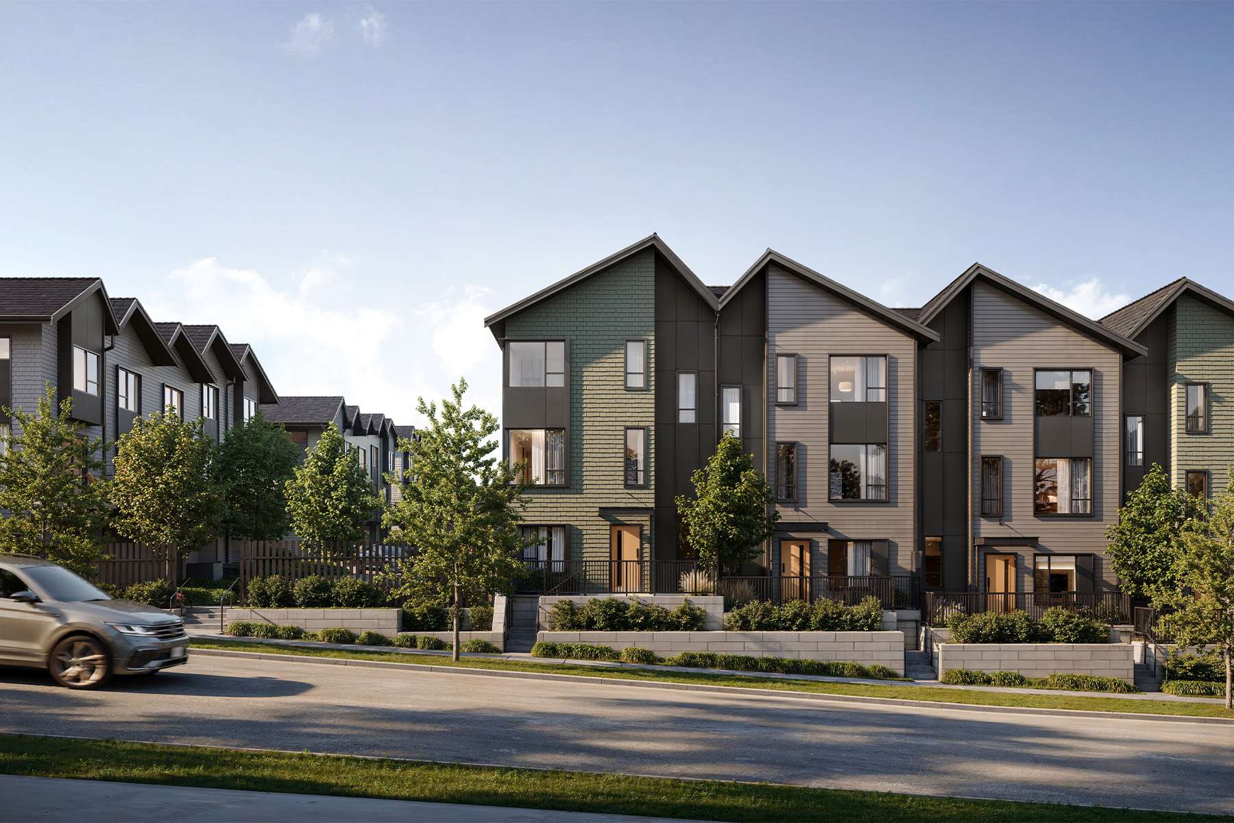 Salton – Street-level view of a row of modern three-story townhomes with green and taupe shake siding and dark gabled rooflines.