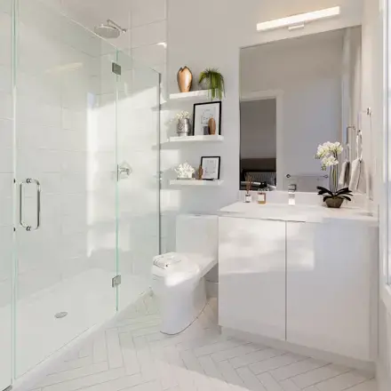 Thomas West Haney – A bright, modern residential bathroom featuring a frameless glass walk-in shower with white subway tiles and a herringbone pattern tile floor. The space is fitted with a floating white vanity, a large mirror topped with a sleek light fixture, and floating wall shelves styled with decorative accents and small plants.
