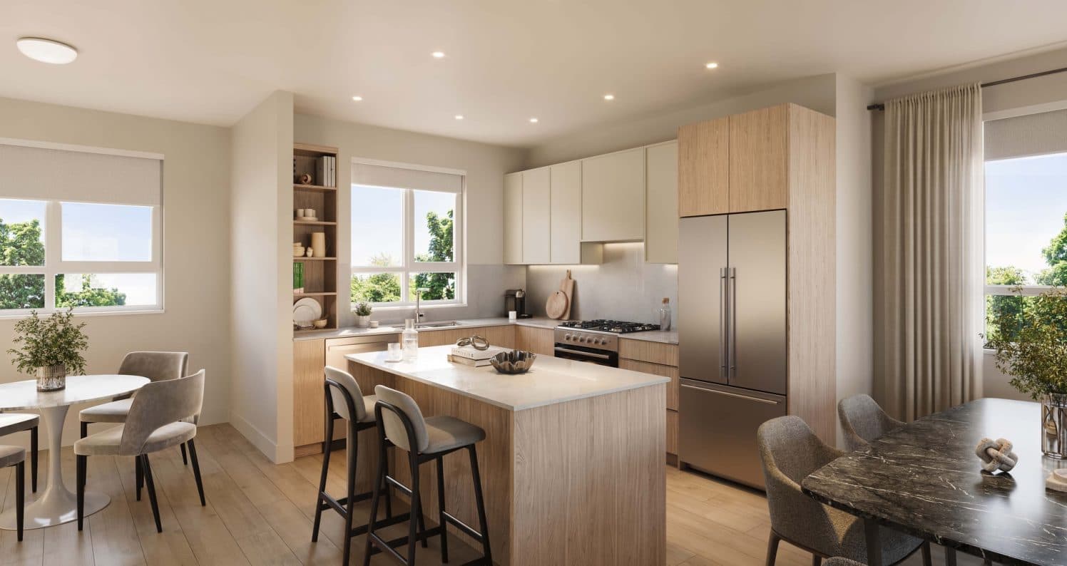 Ferndale Garden 4 – A bright, modern open-concept kitchen and dining area featuring light wood and off-white cabinetry, stainless steel appliances, and a central island with barstools. Large windows let in ample natural daylight, overlooking green treetops outside.