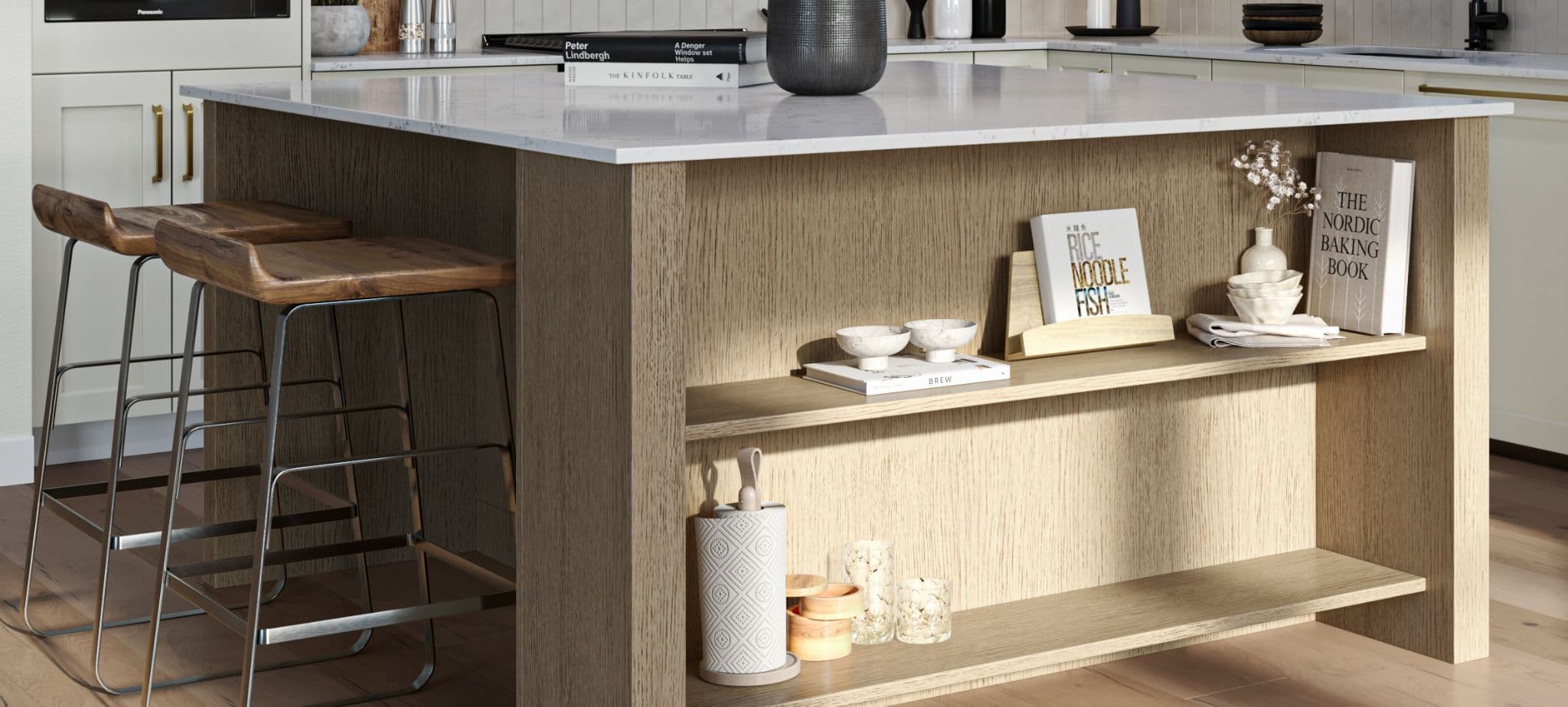 Encore Estates – Close-up of a kitchen island with wood open shelving displaying books and decor, marble countertop, and modern stools.