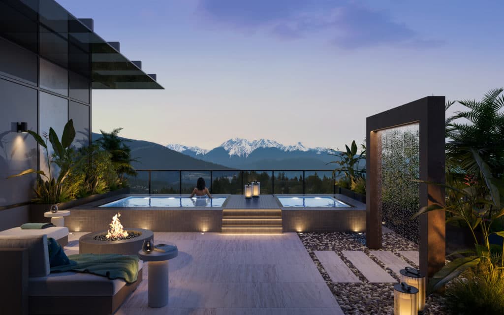 Alina – Rooftop amenity deck at dusk with two hot tub-style plunge pools, a fire pit, lounge seating, and a water feature wall, overlooking snow-capped mountains.