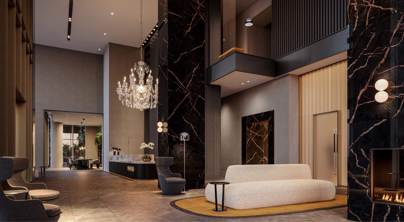Bassano – Double-height building lobby with a large crystal chandelier, dark marble columns, a cream boucle sofa on a round rug, and a fireplace at the far end.