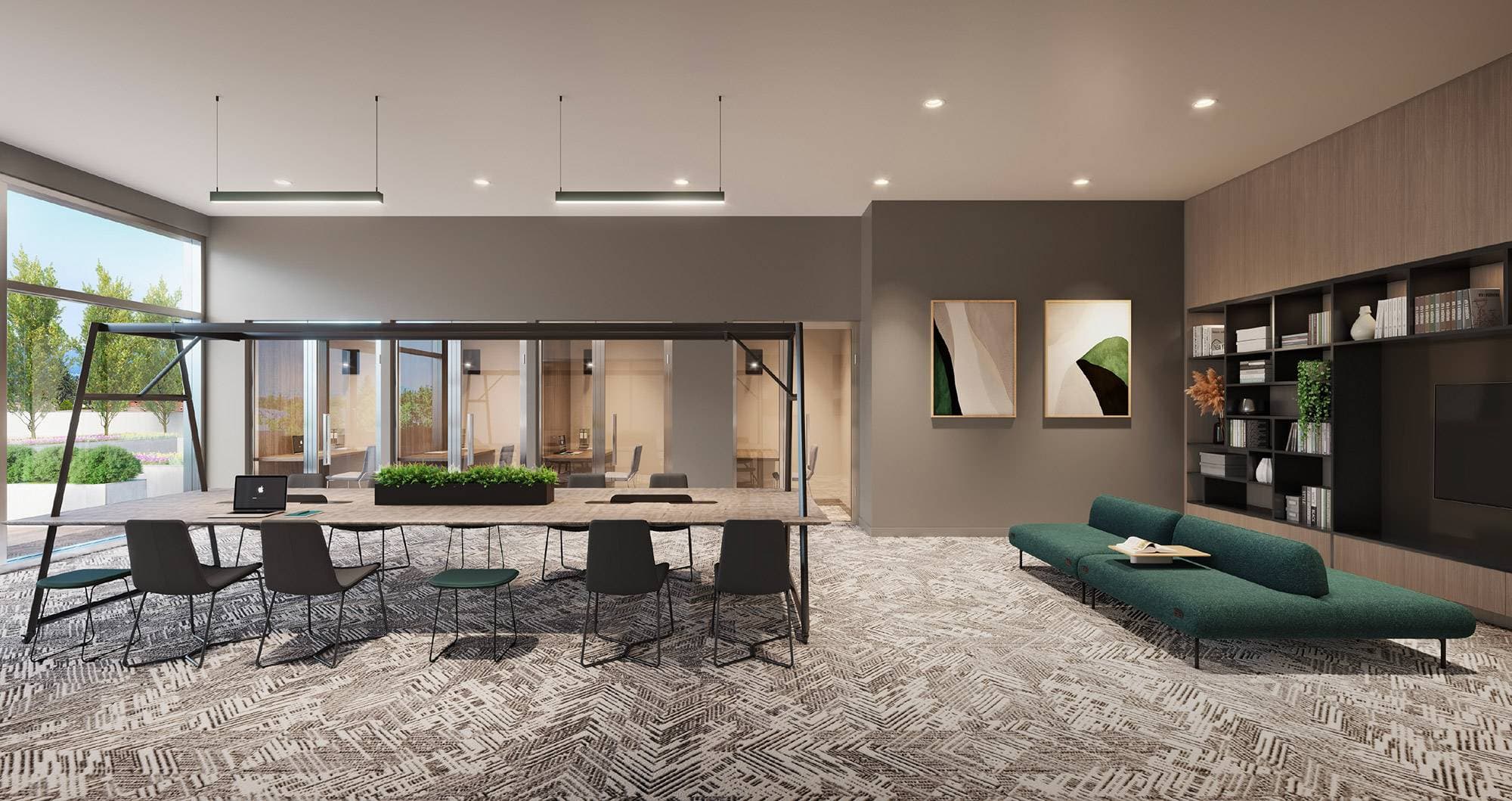 Walker House – A modern co-working lounge features a long wooden communal table with black chairs, suspended linear lighting, and integrated planters. The room includes a low teal sofa, patterned carpet, wood-paneled shelving units, and large floor-to-ceiling windows overlooking an outdoor terrace.