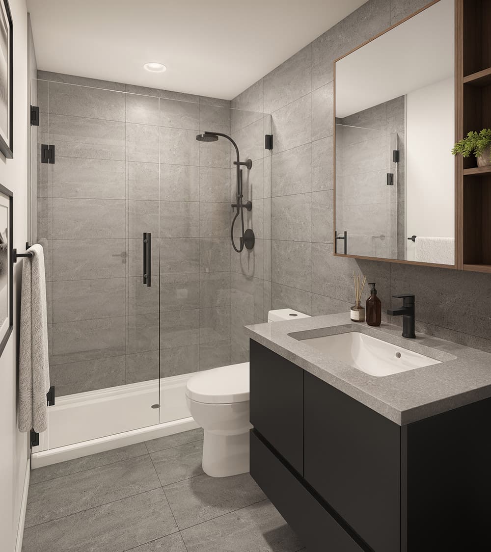 Walker House – A modern bathroom features a glass-enclosed walk-in shower with matte black fixtures and dark gray stone wall tiles. Next to the shower is a floating black vanity with a quartz countertop, an undermount sink, and a wood-framed medicine cabinet with side shelving.