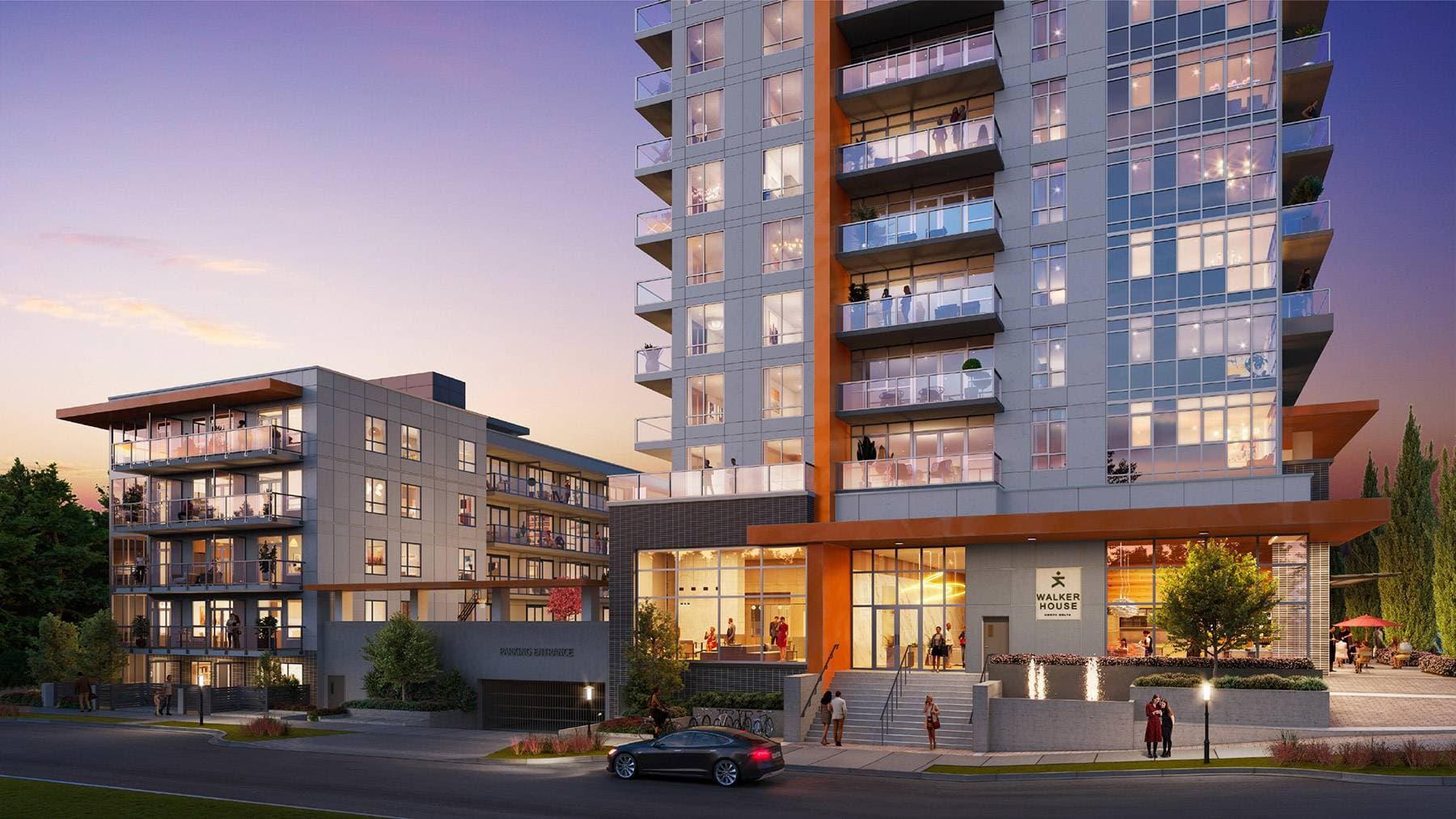 Walker House – A twilight street-level view of a modern residential building featuring a high-rise tower and an adjacent low-rise structure with grey panels and orange accents. Warm light glows from the large ground-floor lobby glass, glass balconies, and apartment windows, with pedestrians on the sidewalk and a car parked out front.