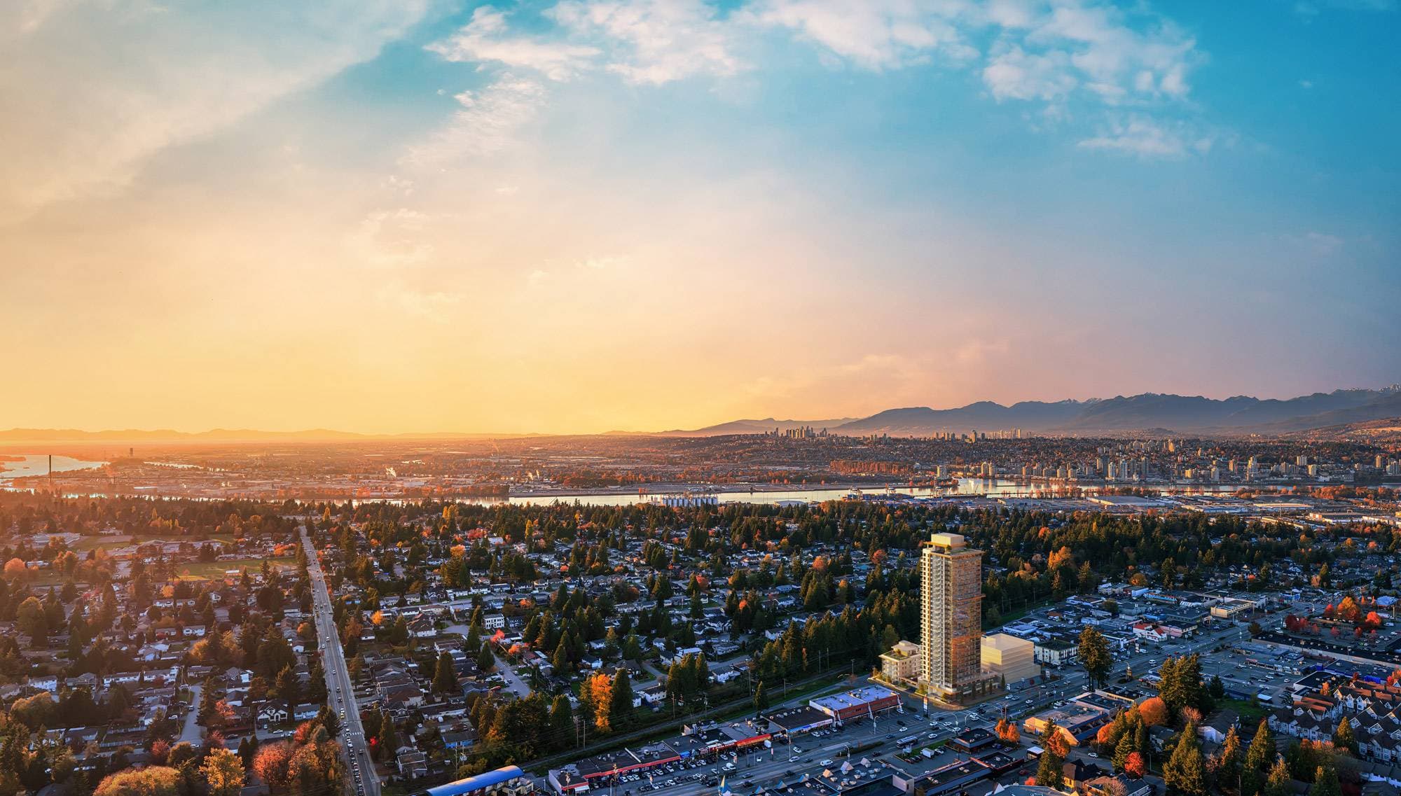Walker House – A high-altitude aerial view looking over a sprawling residential neighborhood toward a distant river, urban skyline, and mountain range at sunset. A highlighted residential high-rise tower stands out among the low-rise buildings and dense green trees under a soft, golden-blue sky.