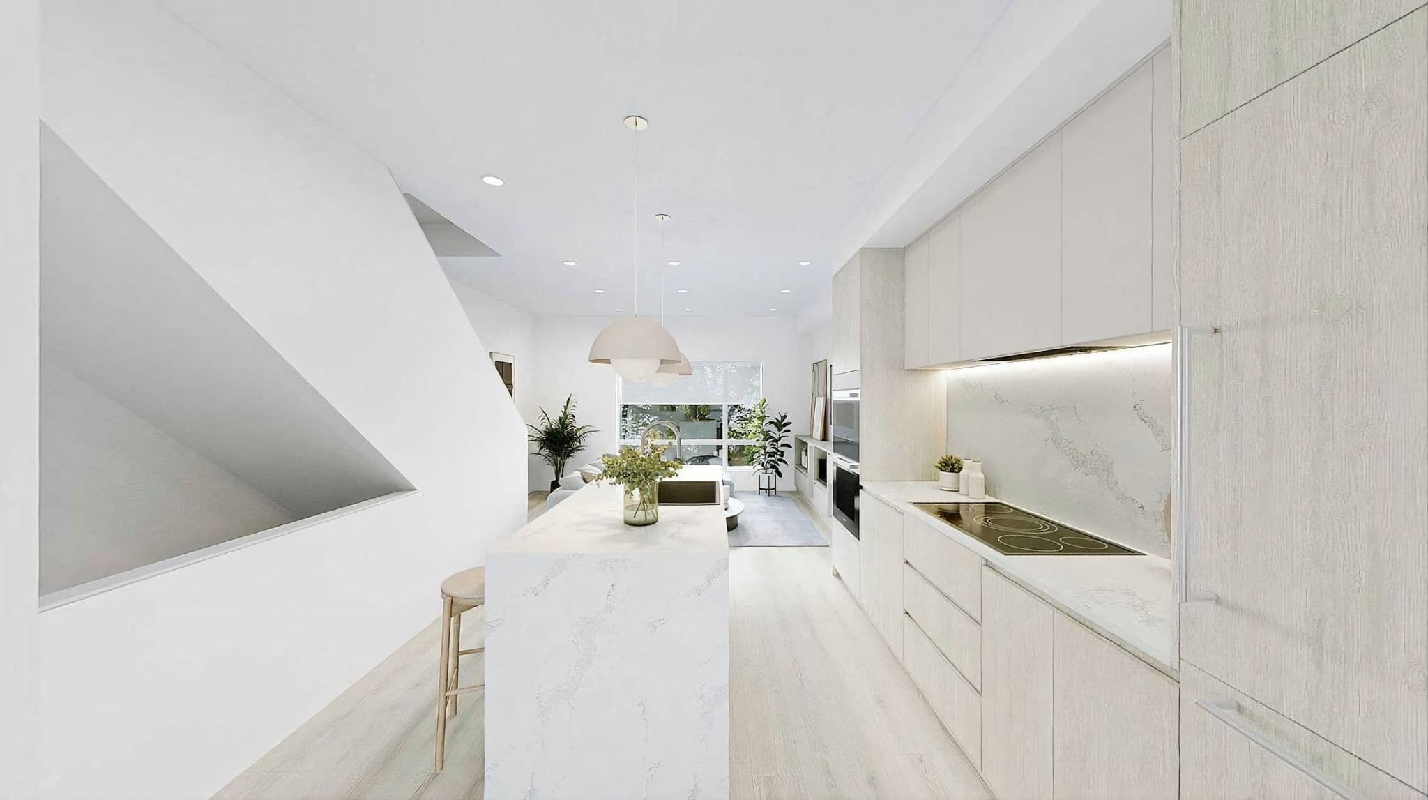 Lotus - The Botanical Collection – Bright kitchen with light wood cabinetry, a marble island with bar stool, and an open sightline to the living room.