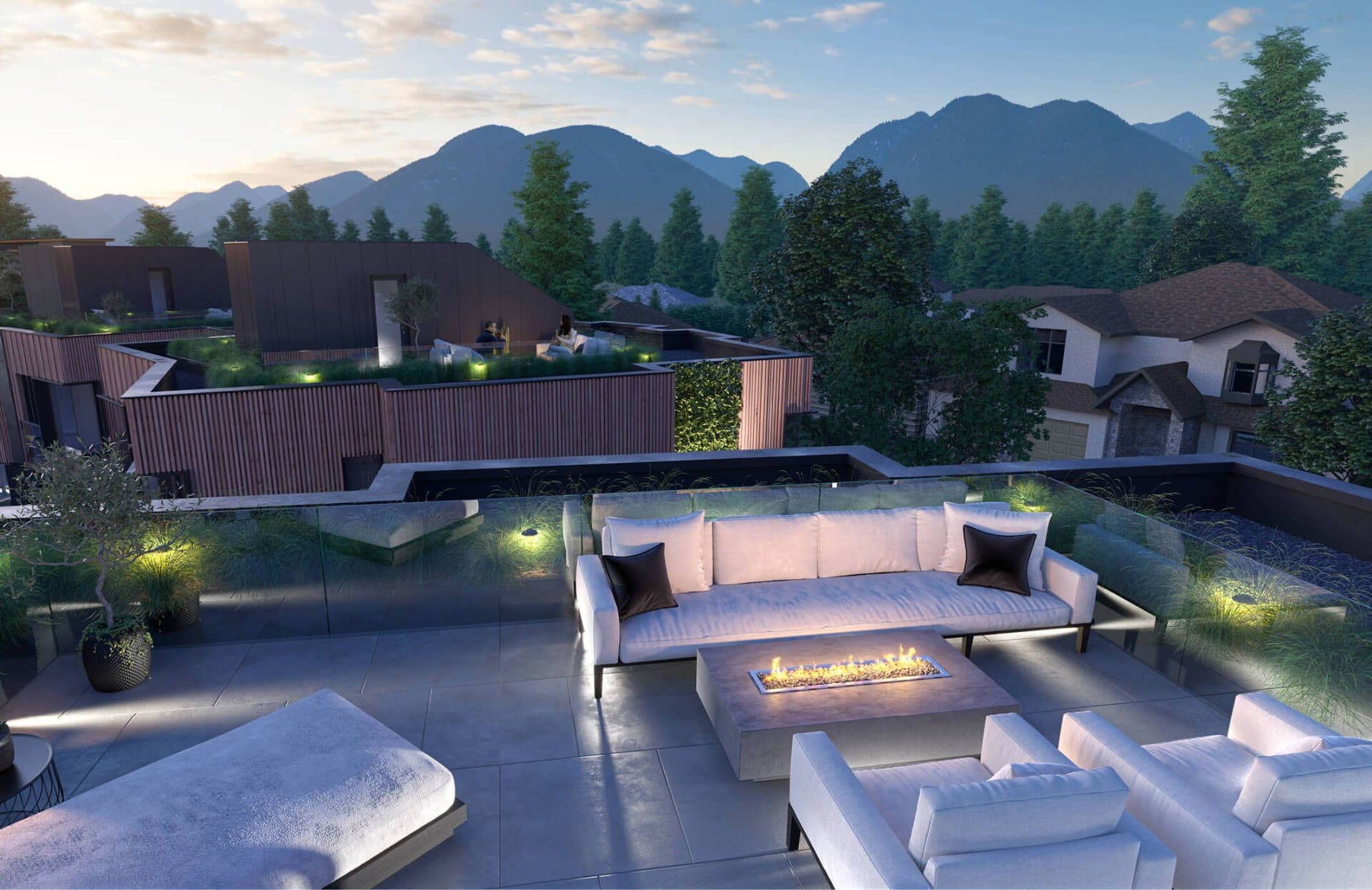 EIGHT – A rooftop terrace at dusk with a large white sectional sofa, a linear fire table, and mountain views in the background.