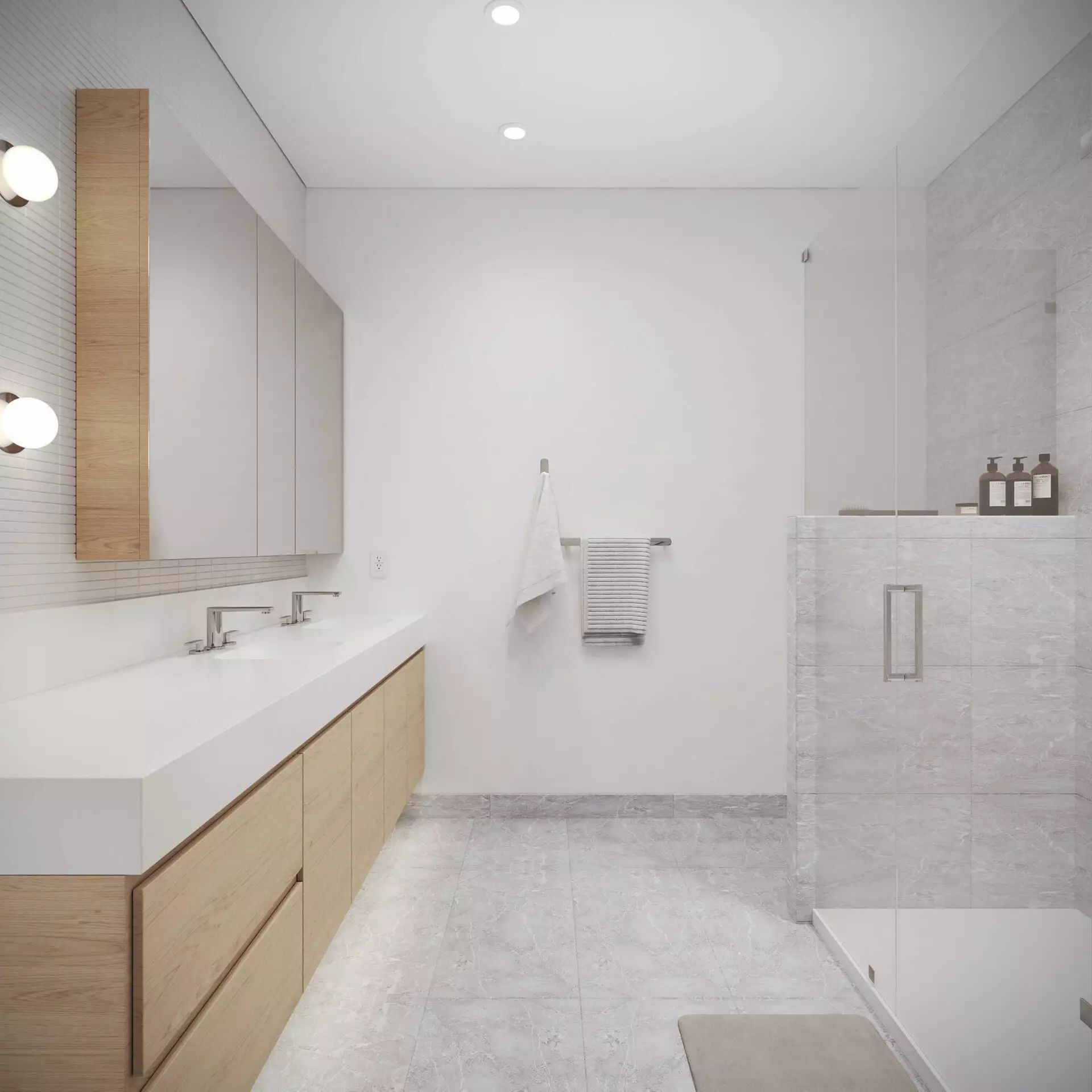 Edge Way at leləm̓ – A modern, bright bathroom featuring a long floating light-wood vanity with a thick white countertop, dual undermount sinks, and chrome faucets beneath a mirrored medicine cabinet. Opposite the vanity is a glass-enclosed walk-in shower lined with light gray marble tiles that match the flooring, set against crisp white walls.