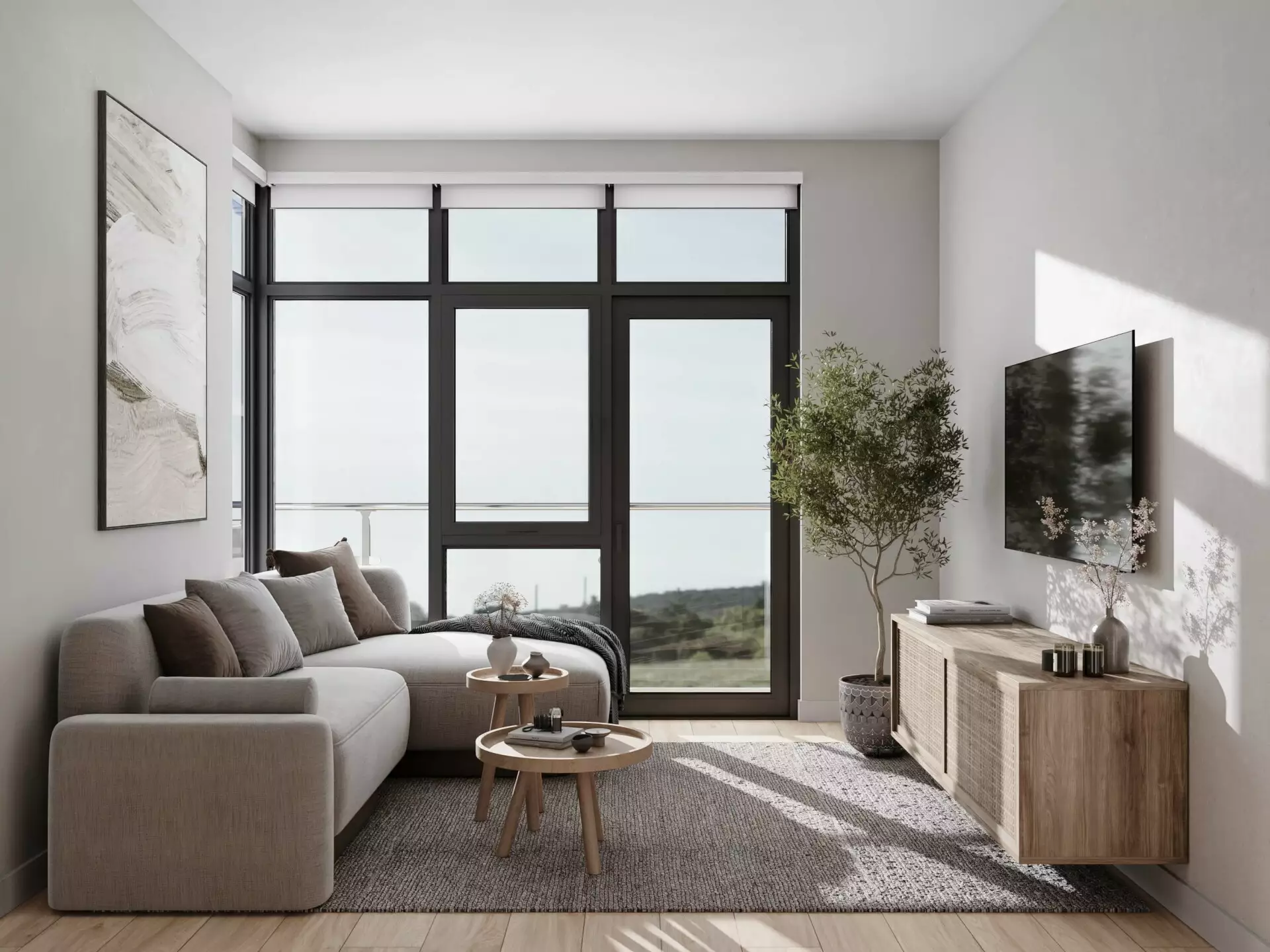 Edge Way at leləm̓ – A sunlit modern living room featuring a light grey sectional sofa, round wooden coffee tables, and a wood media console with a wall-mounted TV. Large dark-framed glass doors and windows open onto a balcony overlooking green hills, filling the minimalist space with bright daytime light.