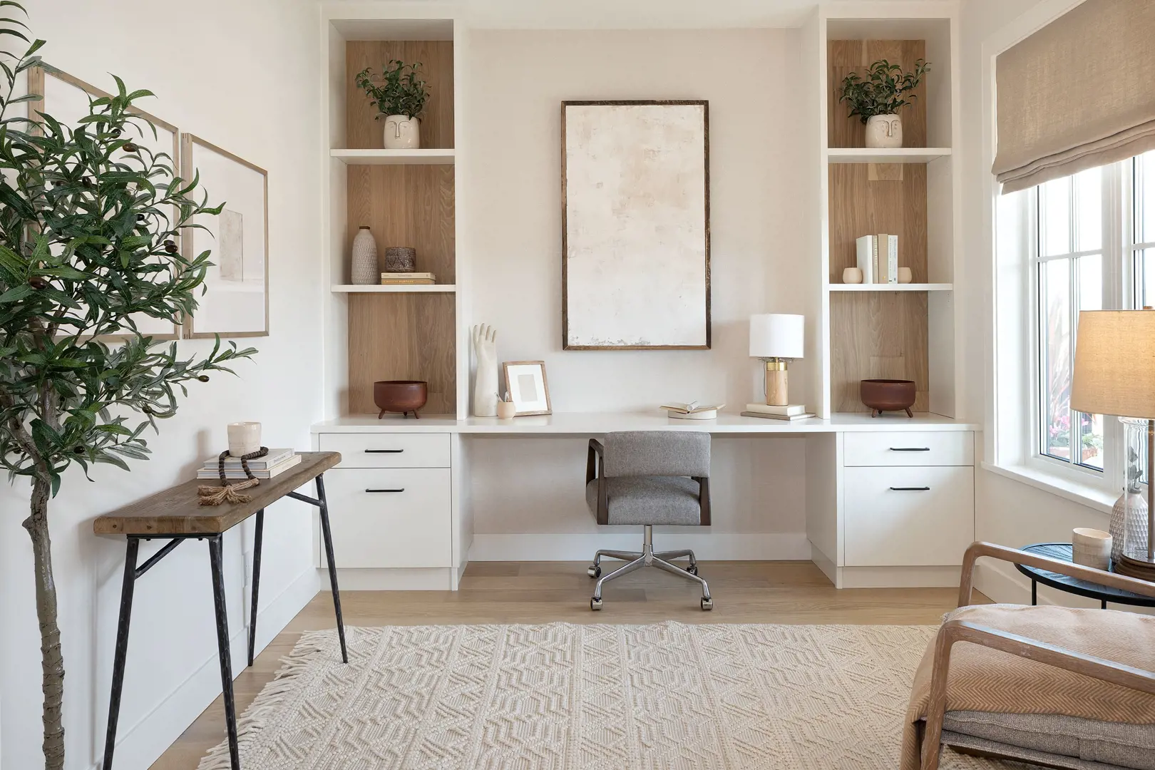 Ridgemont – Home office nook with built-in shelving, a white desk, gray task chair, and a large abstract framed artwork on the wall.