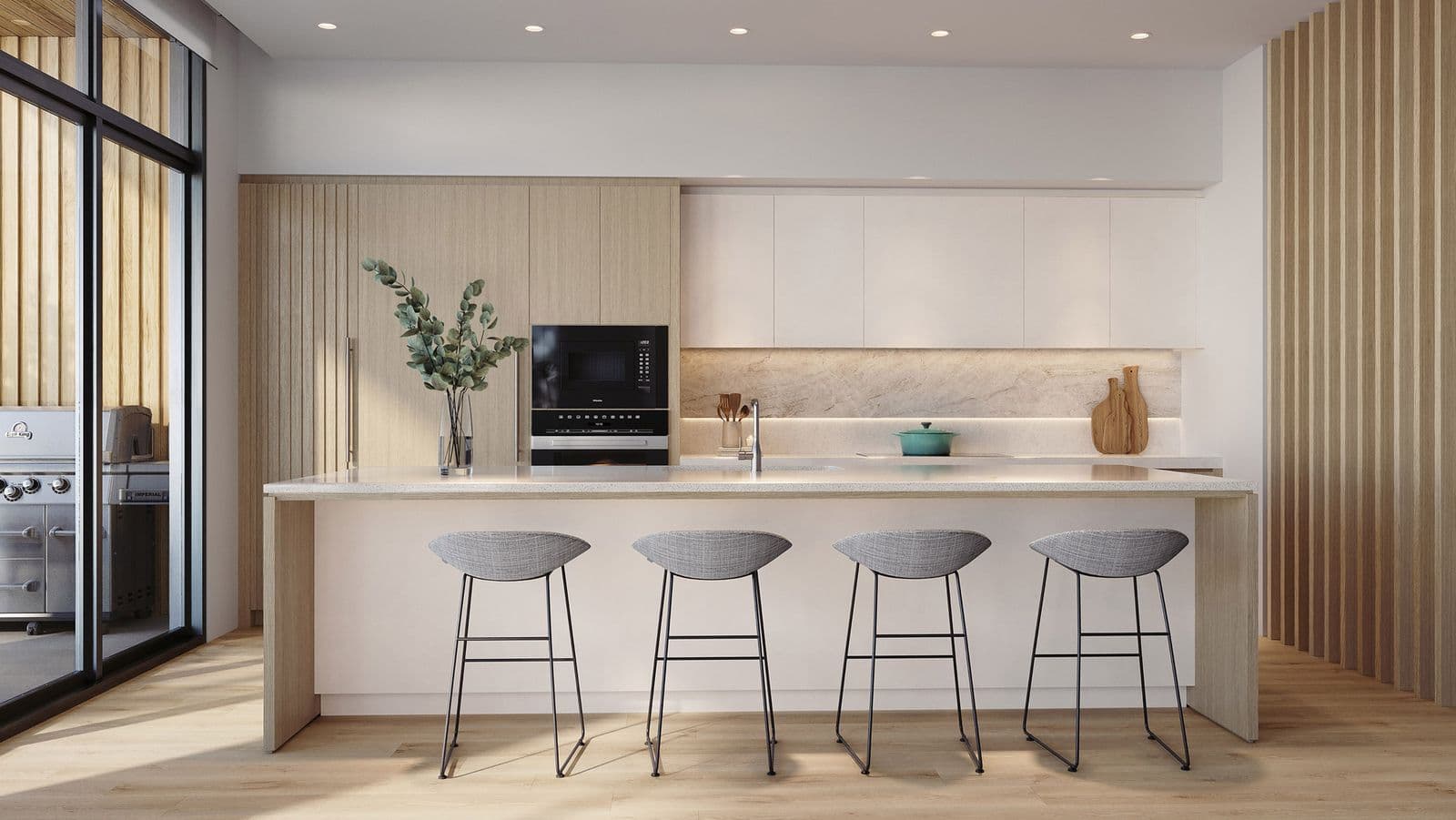 Wildwood at Uplands – Kitchen with light wood cabinetry, a built-in wall oven and microwave, stone-look backsplash, and an island with gray bar stools; wood slat wall to the side and a BBQ visible on the balcony beyond.
