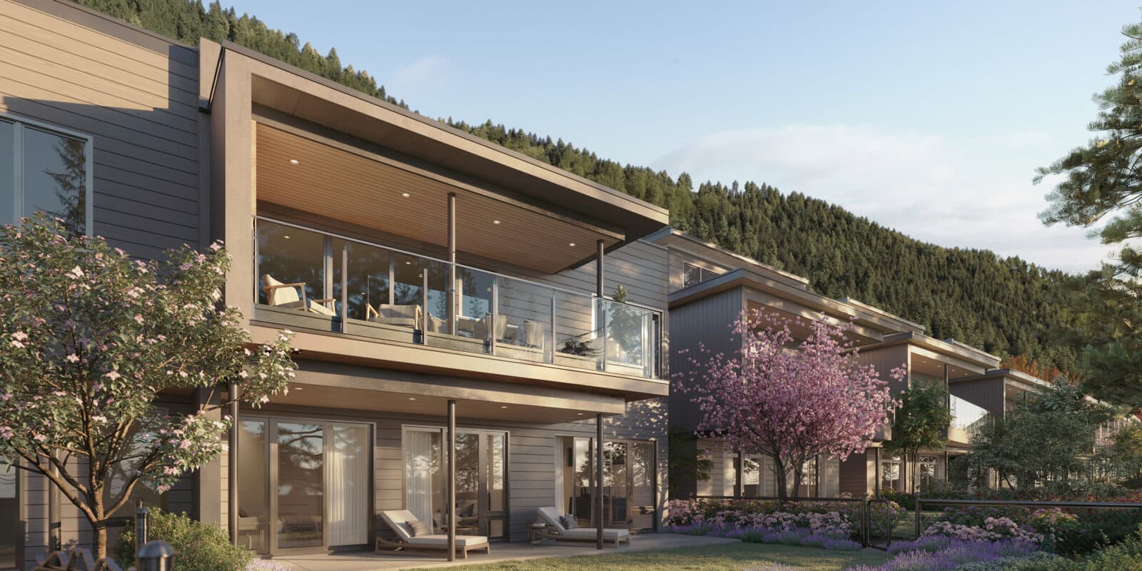 Wildwood at Uplands – Close-up rendering of two-story homes with a covered upper balcony, wood siding, and flowering cherry trees in the front garden.
